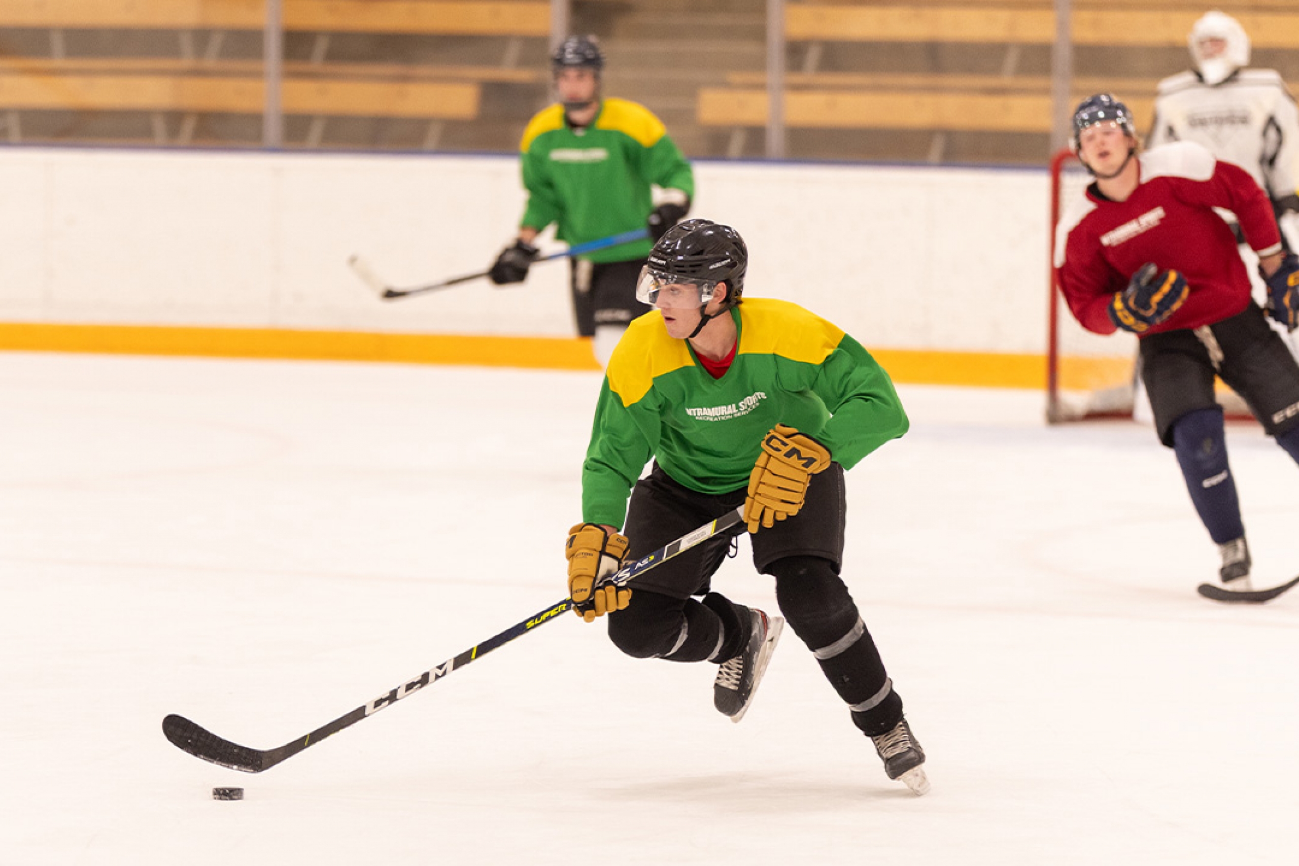 A hockey player during an intramural game skating with the puck
