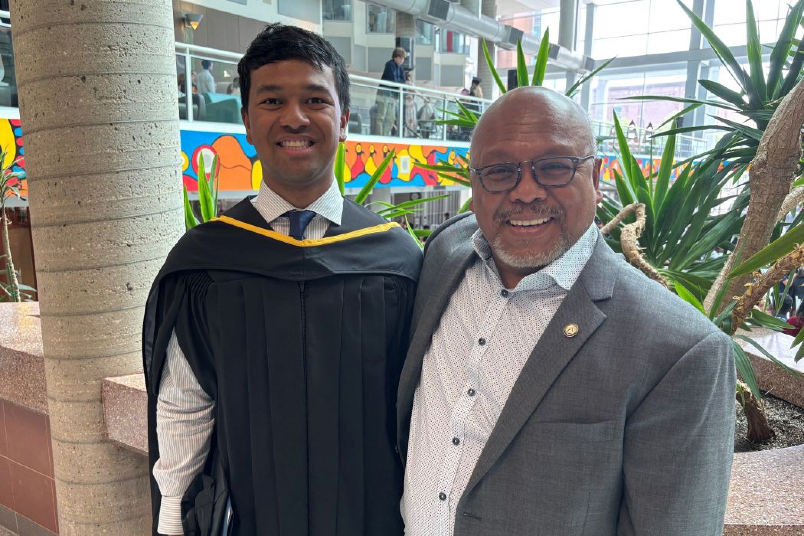 Portrait of Dr. Nick Colina and Dr. Tom Colina. Nick is wearing a graduation gown. 