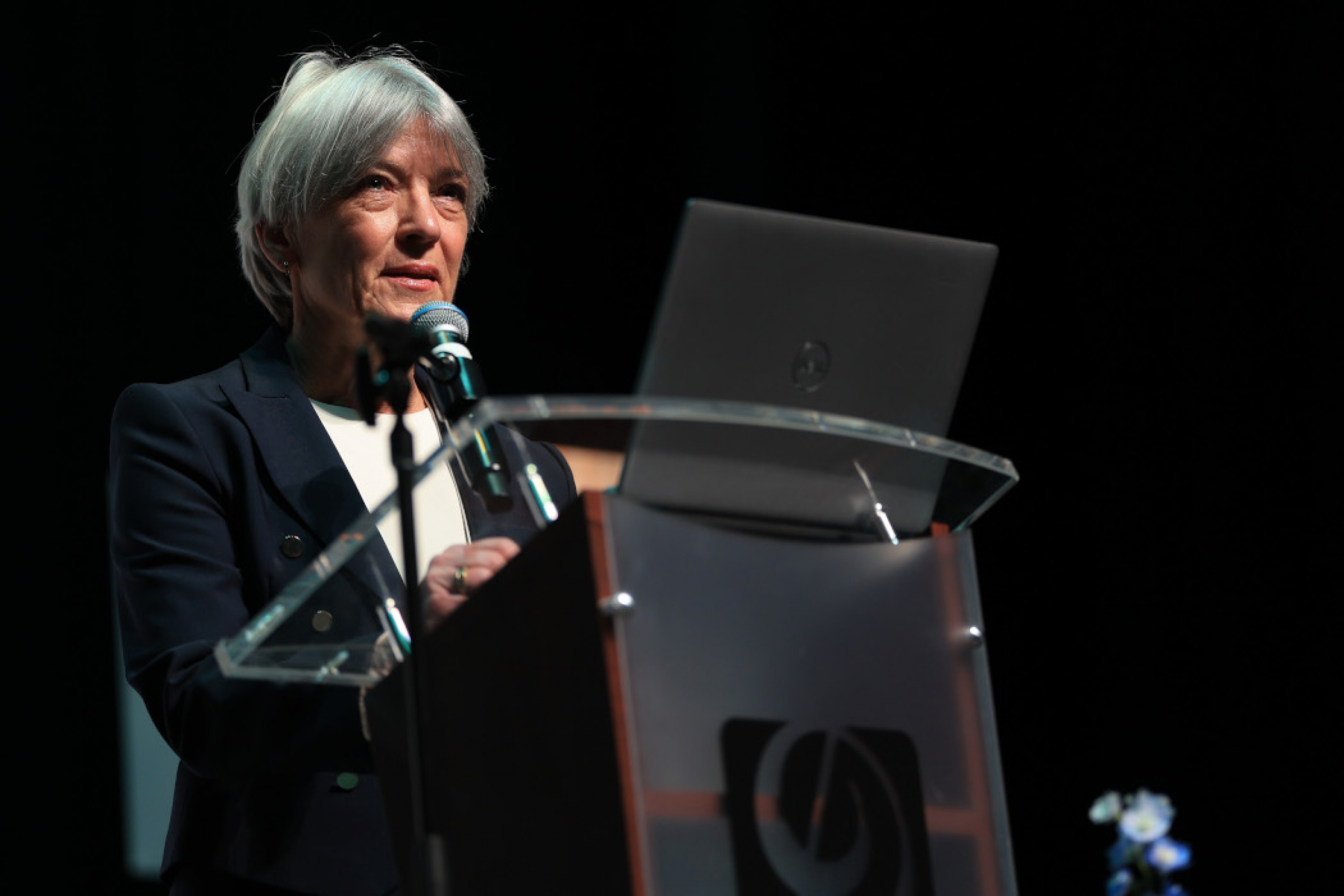 Dr. Greta Cummings speaks at a lectern. 