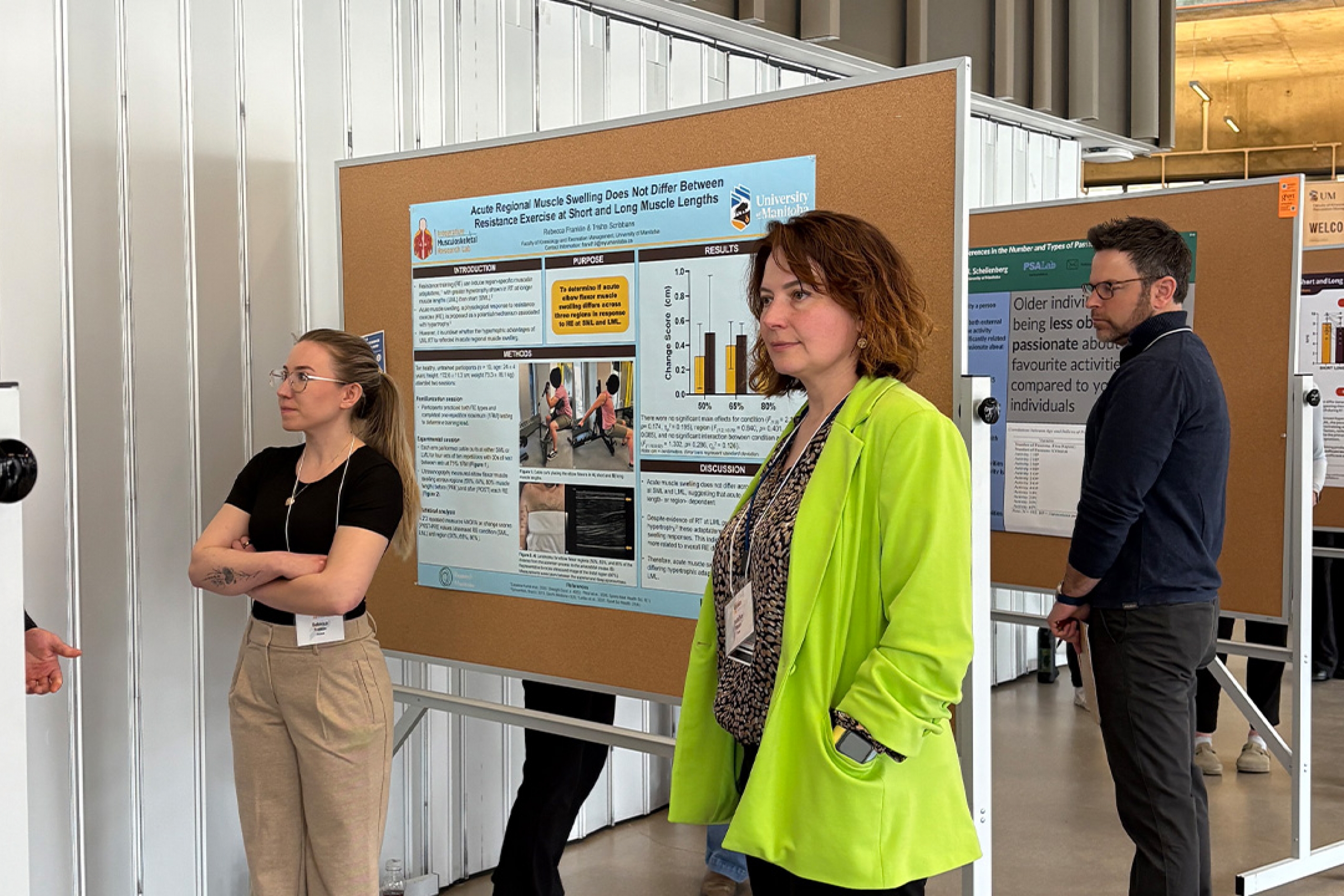 A woman in a green blazer looking at posters during Research Day 20206