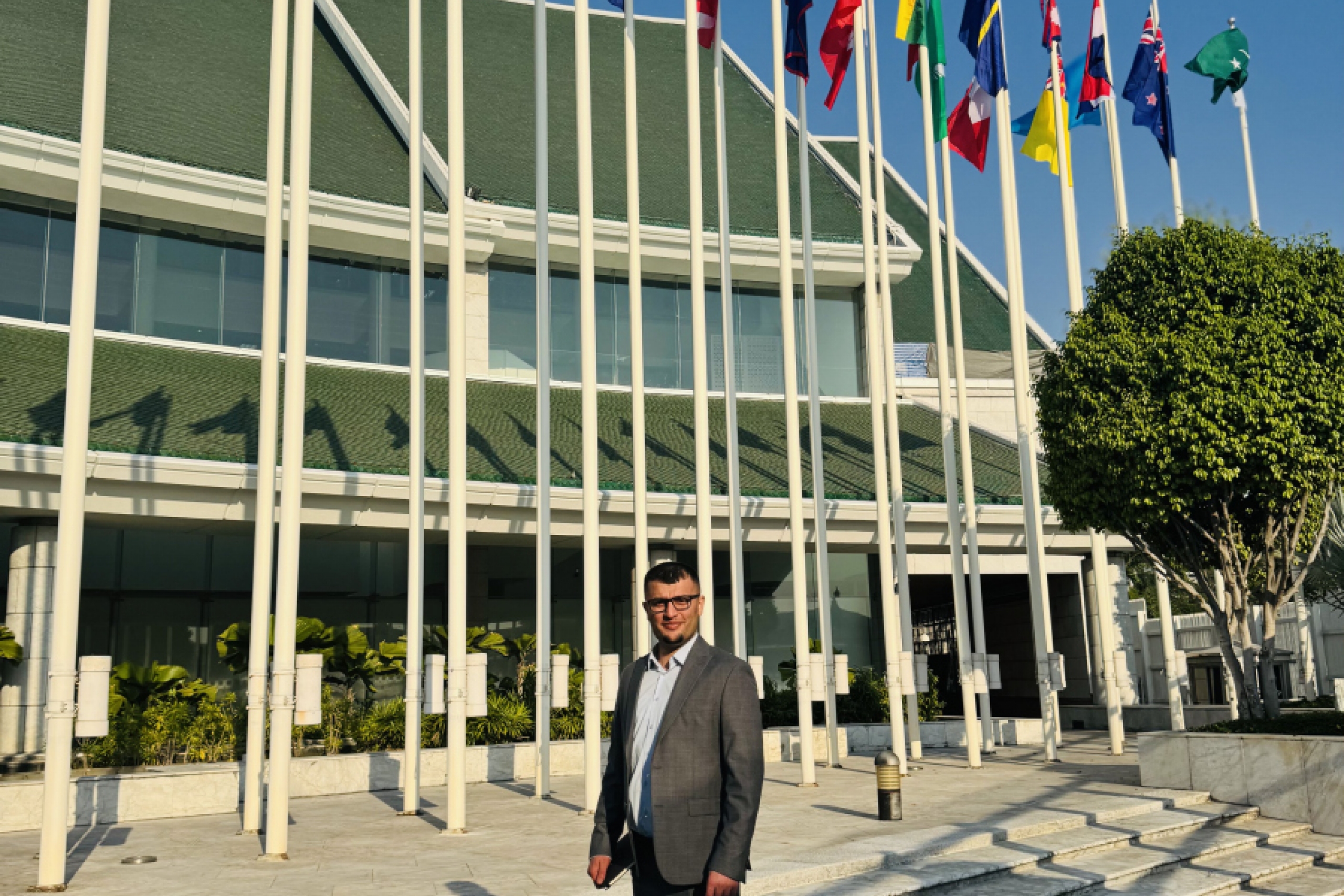 Rosty Othman outside of the United Nations Conference Centre  where there stands flags from all over the world