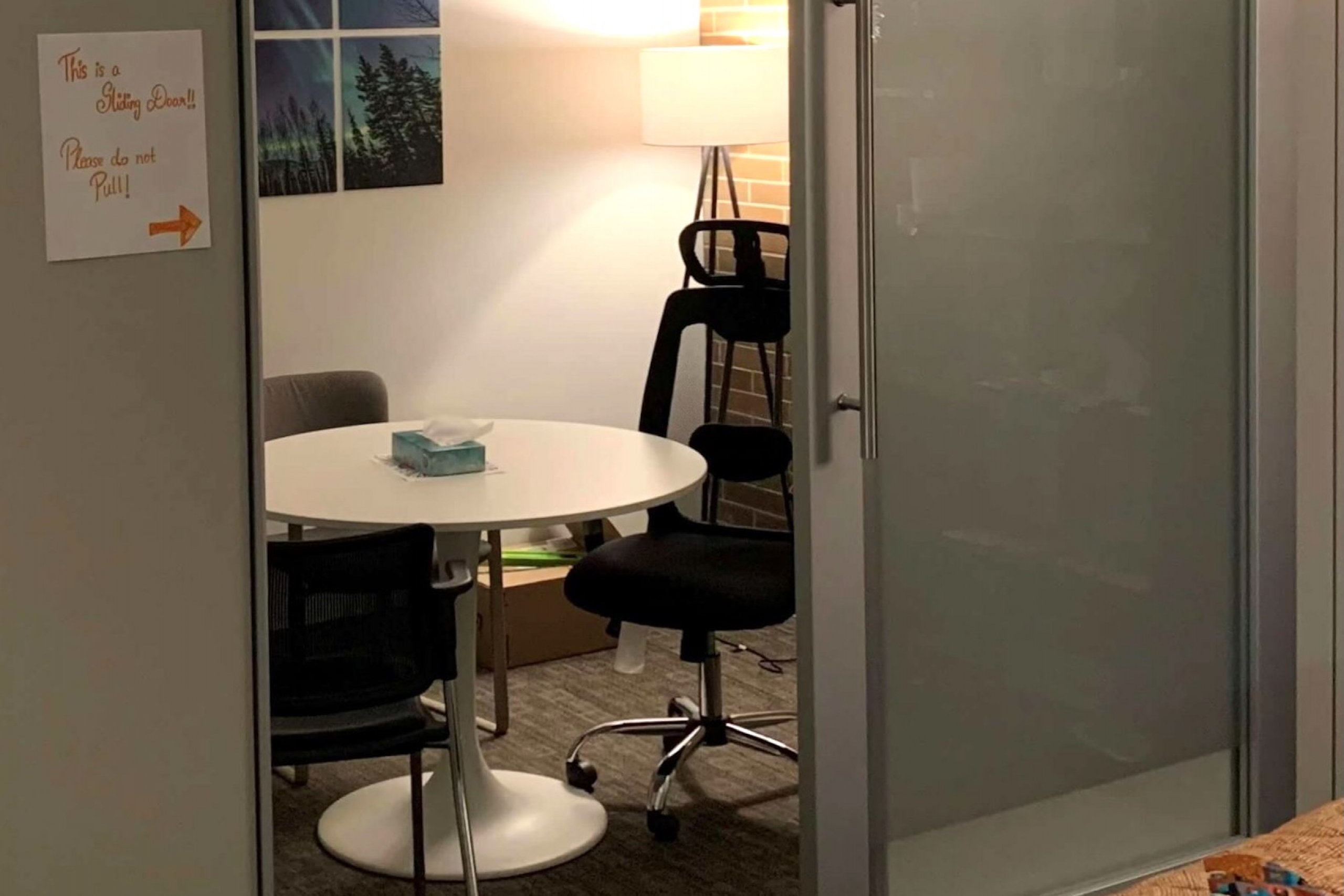 Doors slightly ajar, looking into a private room with table and chairs.