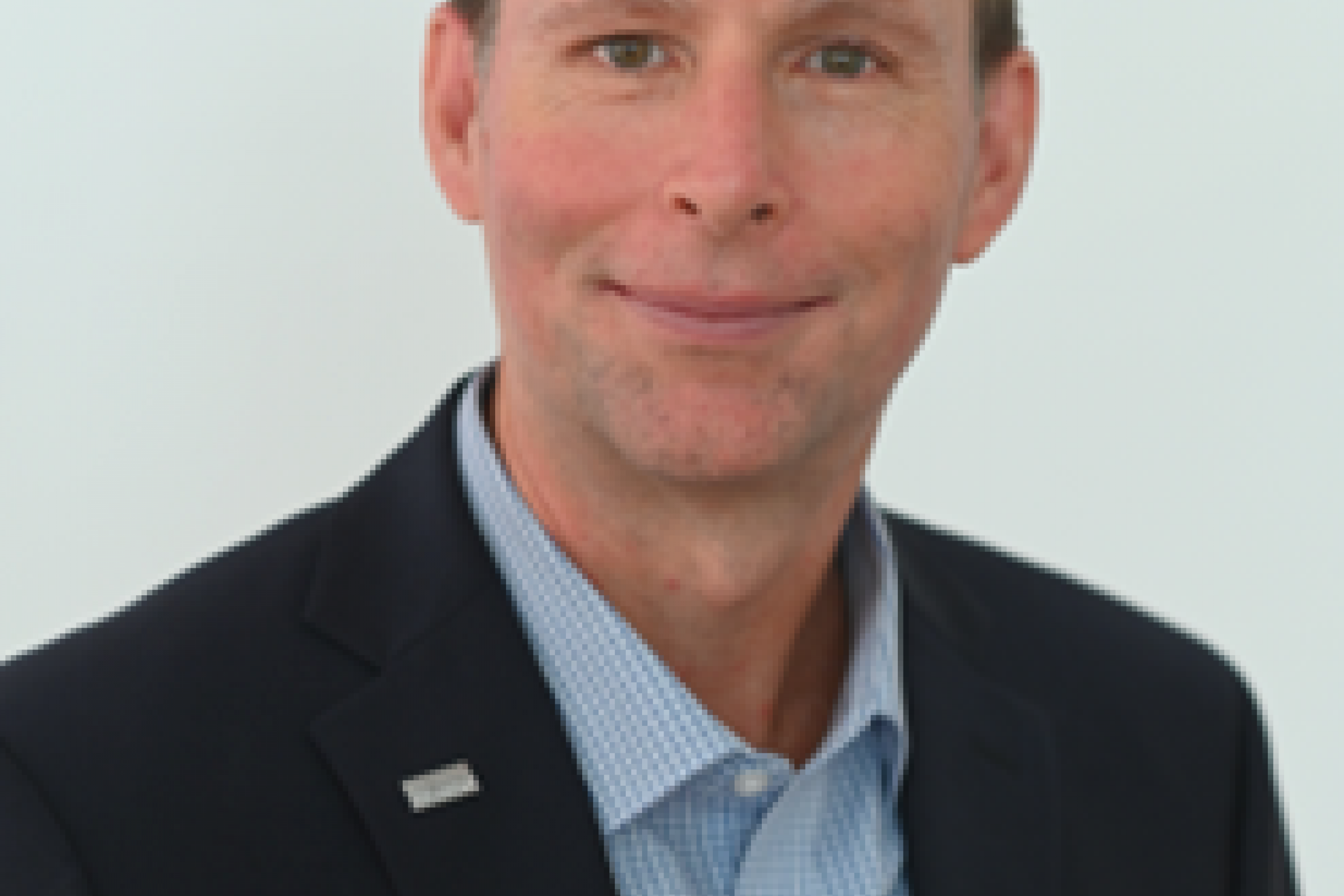 portrait of male with light brown hair, blue dress shirt and black suit jacket