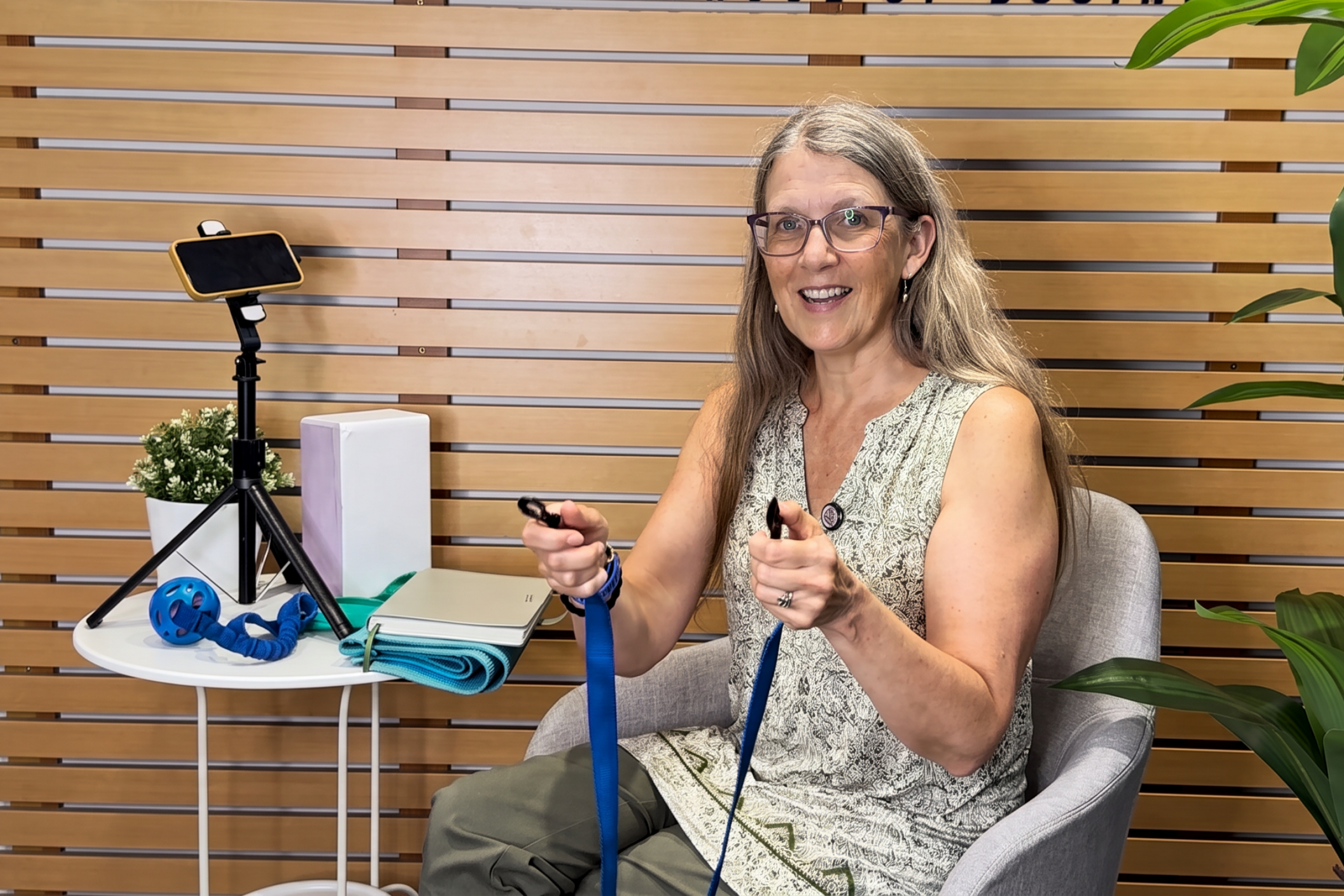 Selena Randall smiles while sitting for an interview at the SCCE and holding a blue dog leash