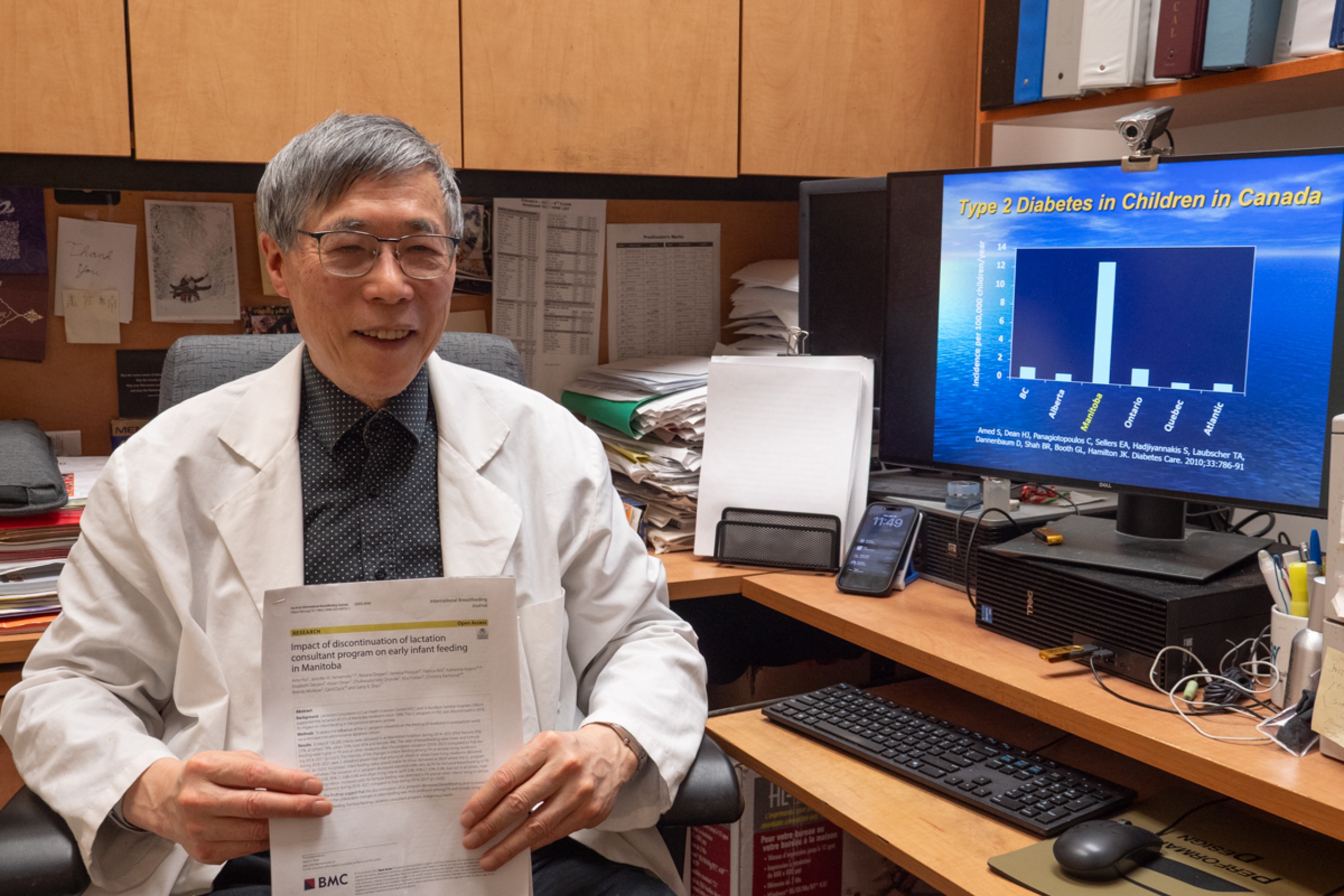 Dr. Shen sits in his office, holding a print out of their research.