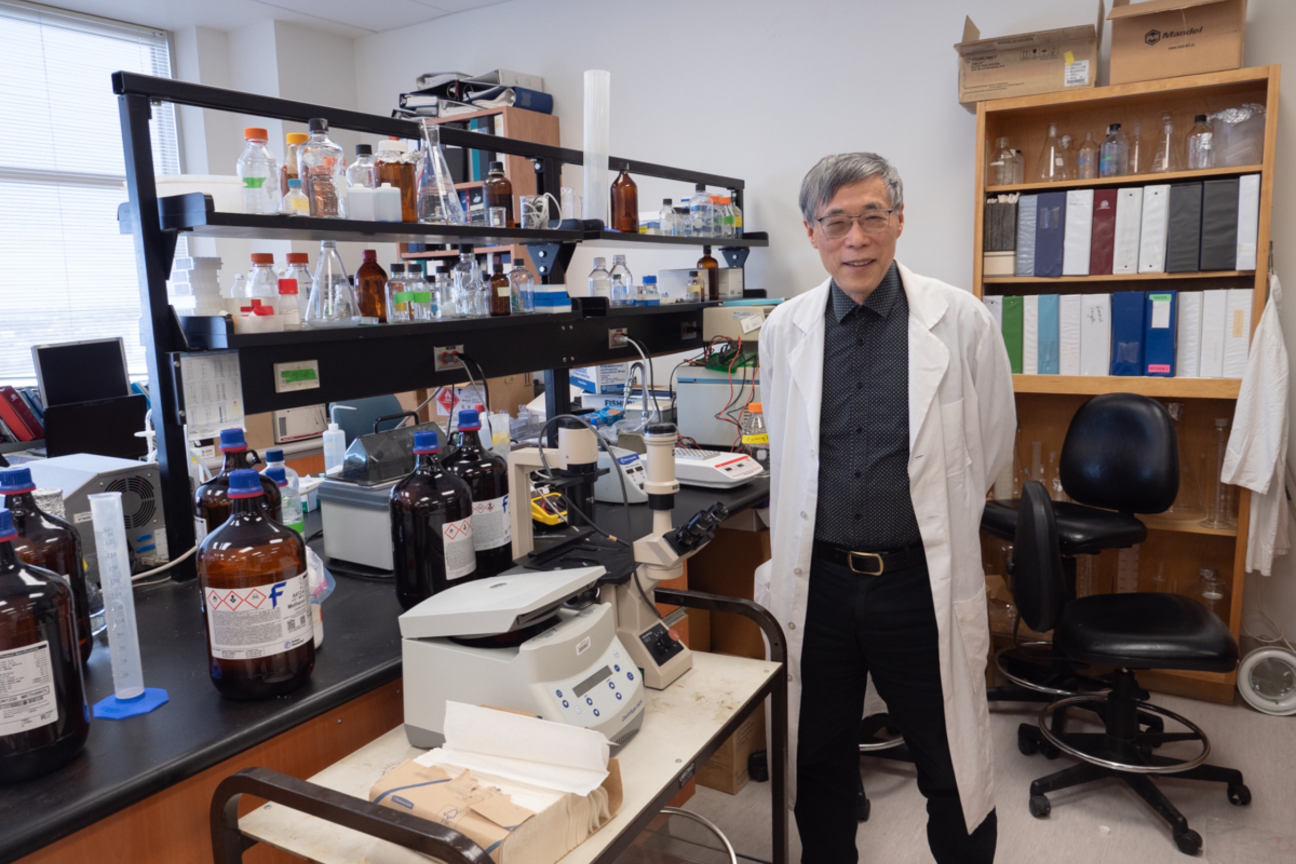 Dr. Garry Shen in his lab, smiling at the camera.