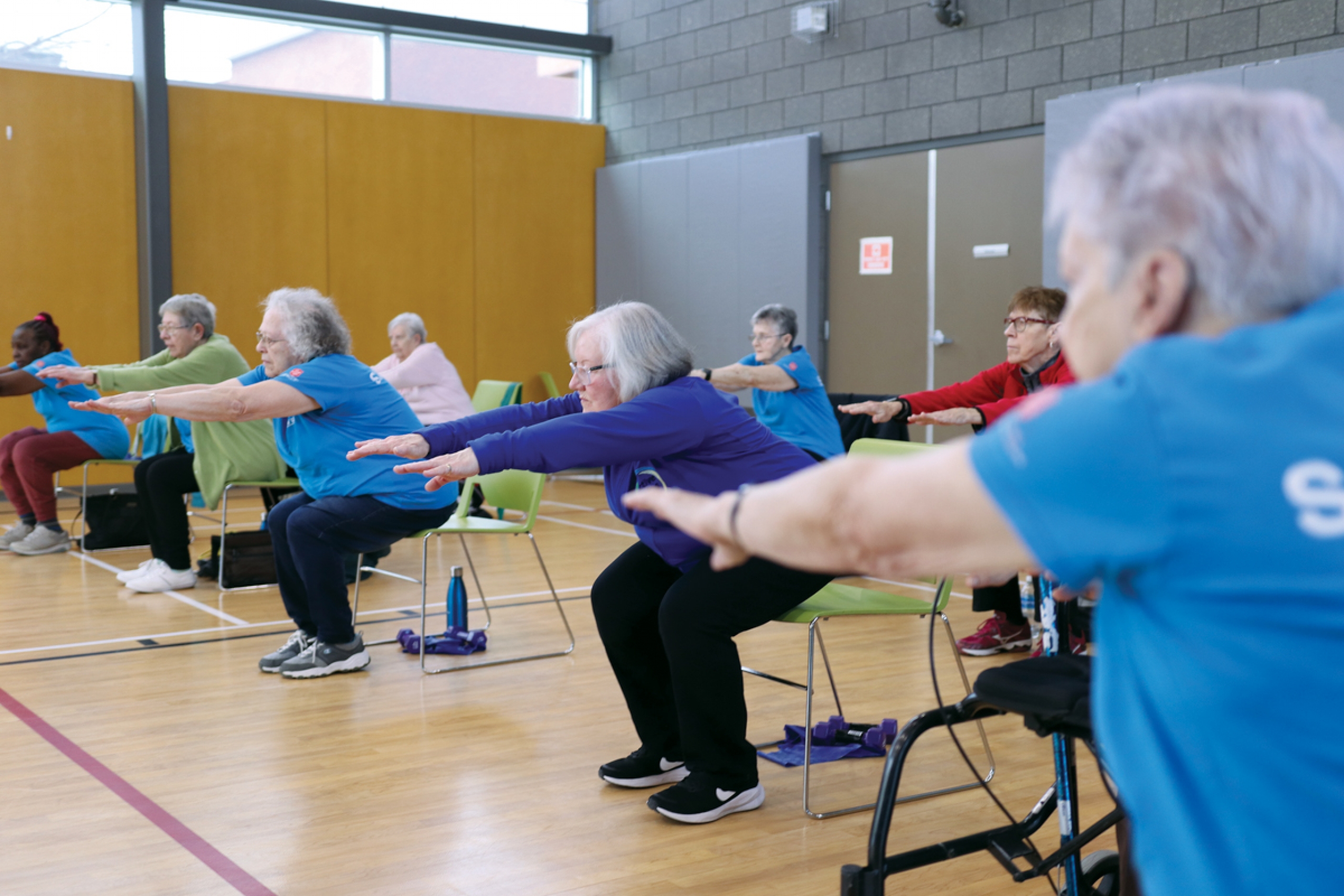 A group of seniors doing an exercise at a gym.