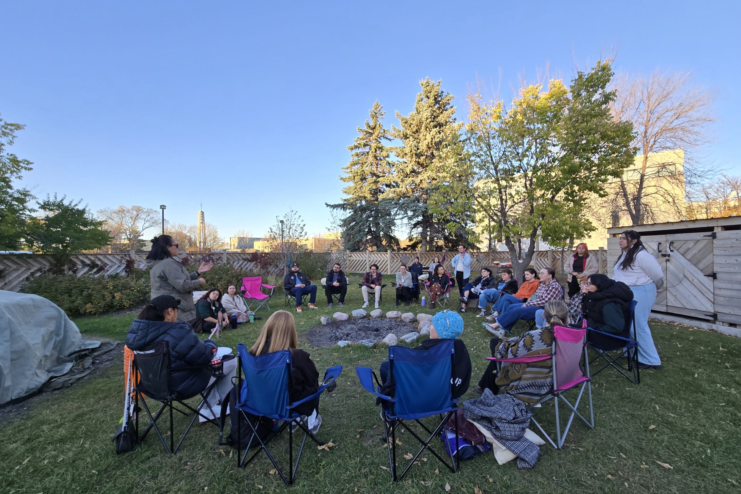 group of students sitting in a circle in the Sweat Lodge Ceremony Space at UM.