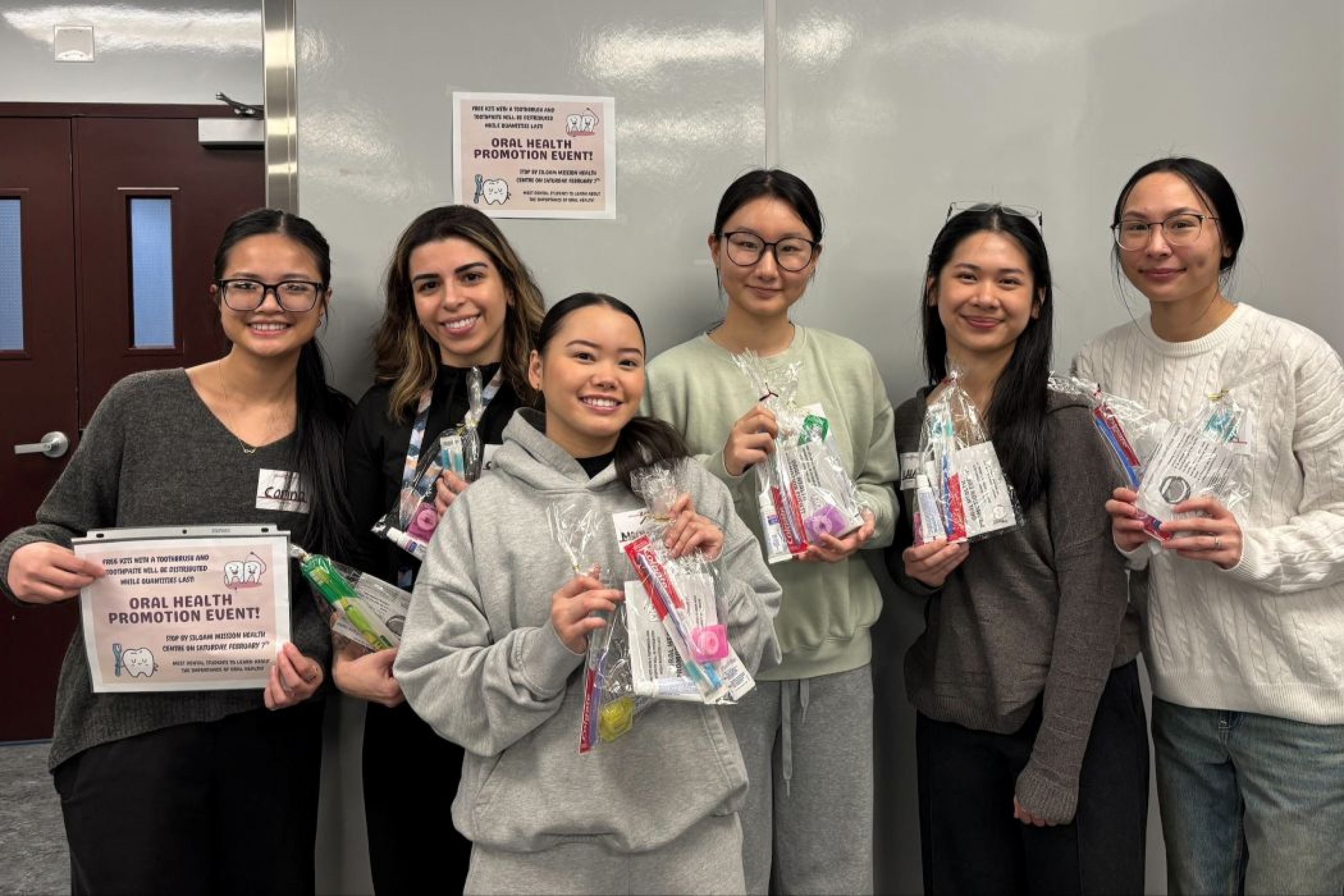 Six students hold dental kits. 
