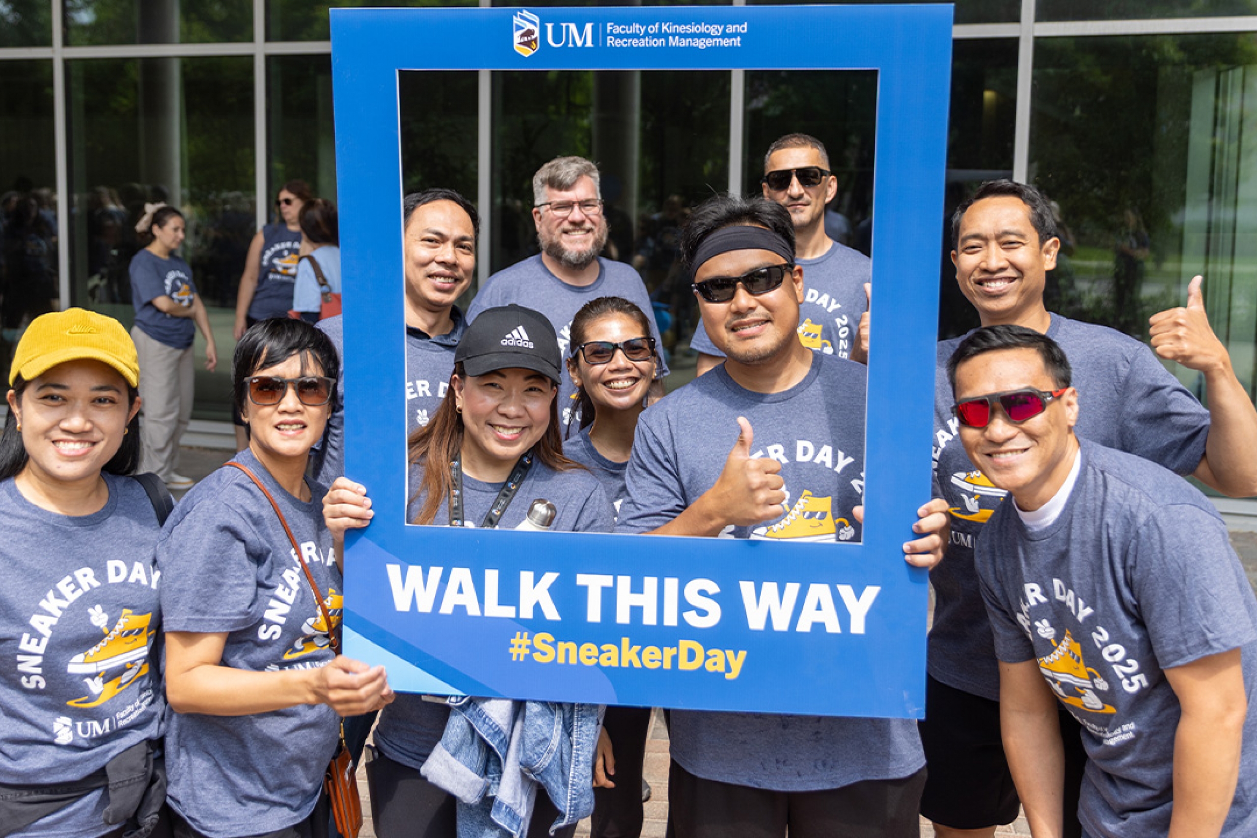 A group posing with a photo frame at Sneaker Day 2025