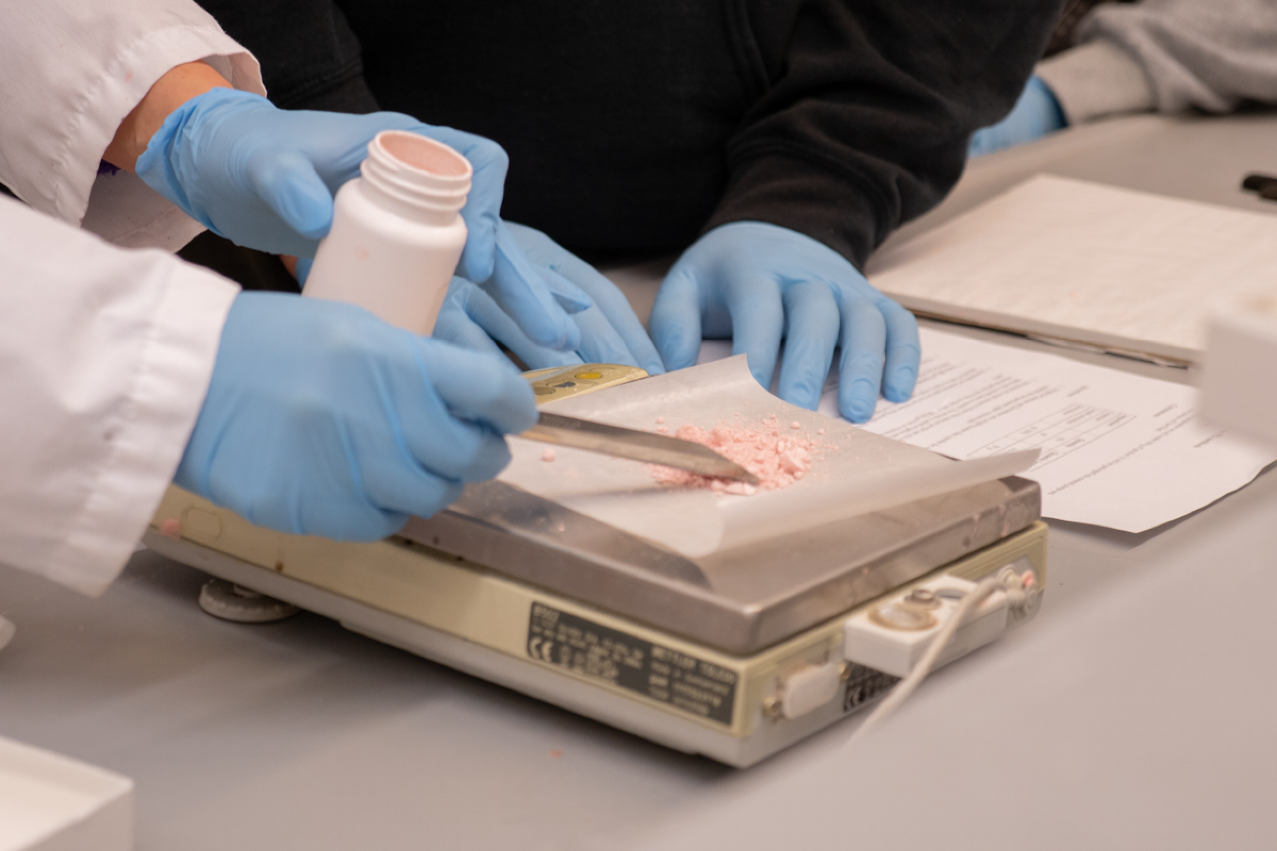 Ingredients being mixed on a scale in a lab.