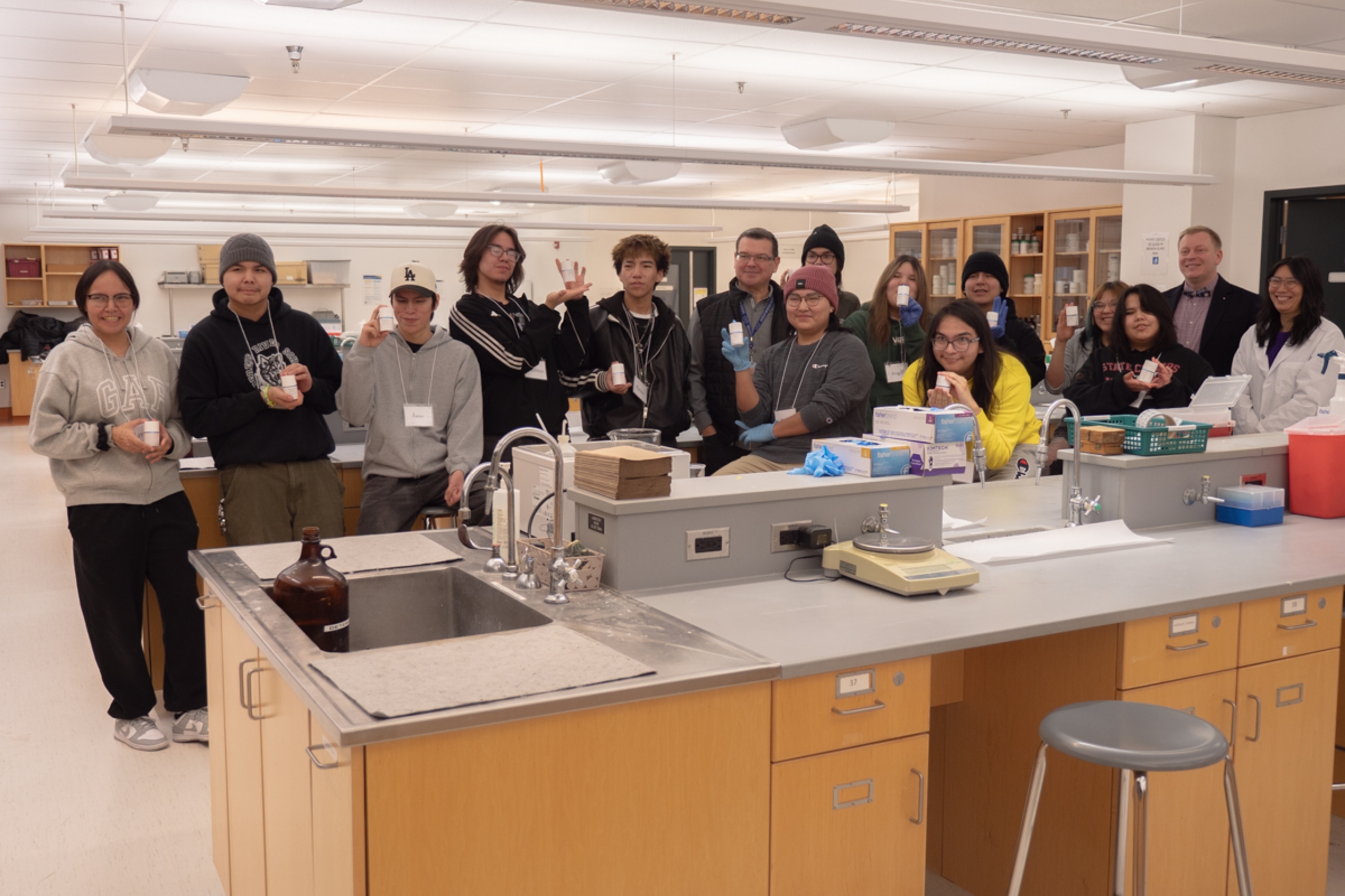 Southeast Collegiate class takes a group photo in a lab, while holding the sunscreens that they made.