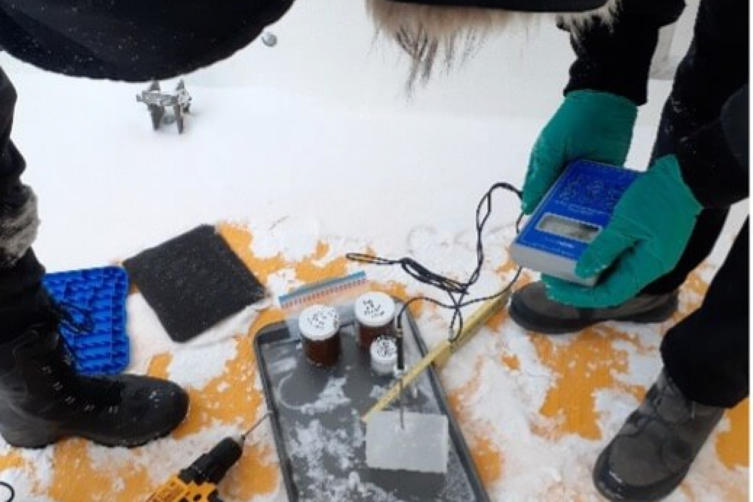 Researchers using various tools to assess the temperature of an ice core.
