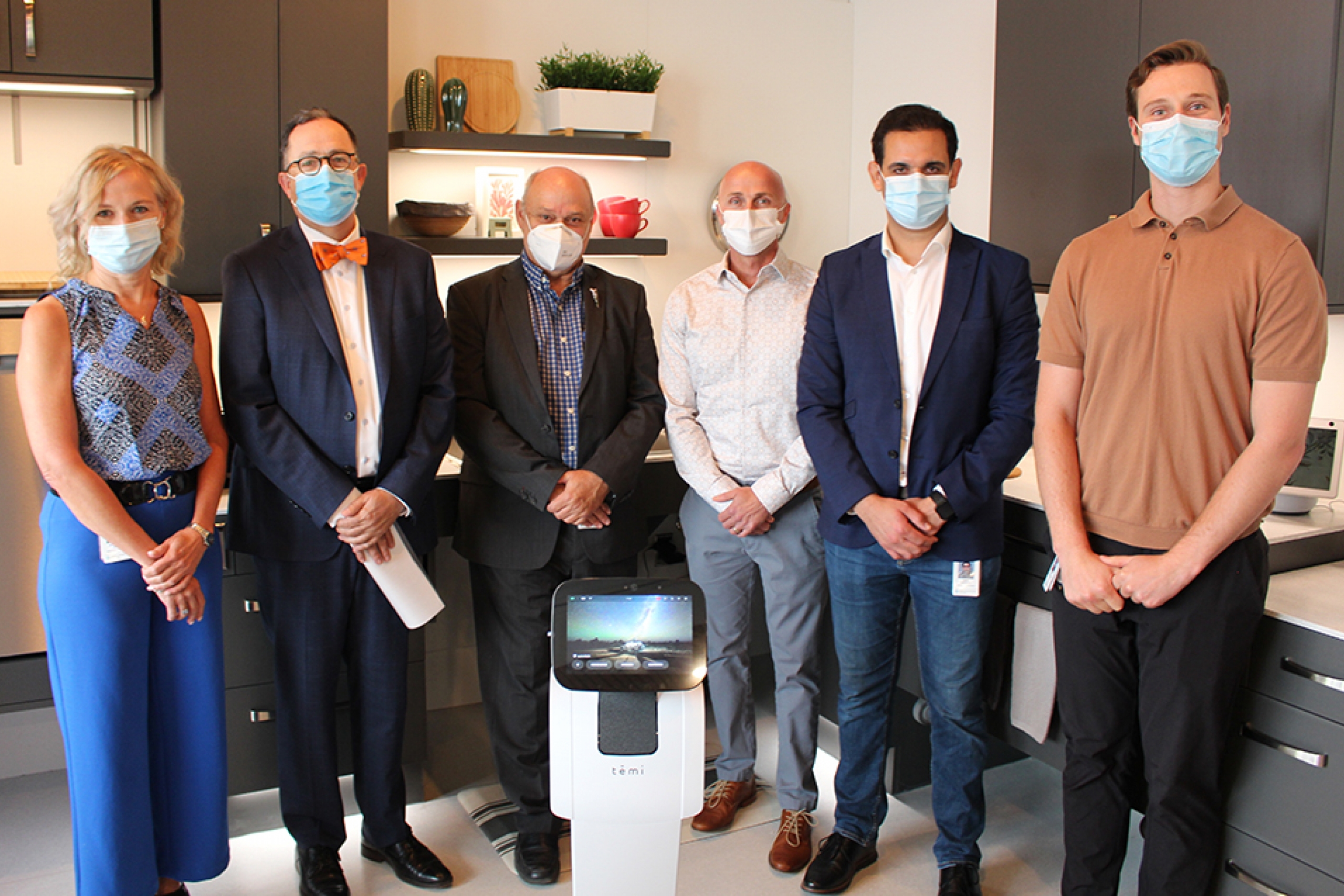 Dr. Jacquie Ripat, Dr. Peter Nickerson, Dr. Reg Urbanowski, Steve Friesen, Dr. Amine Choukou, and Eric Koskie pose in the smart suite with a telepresence robot.