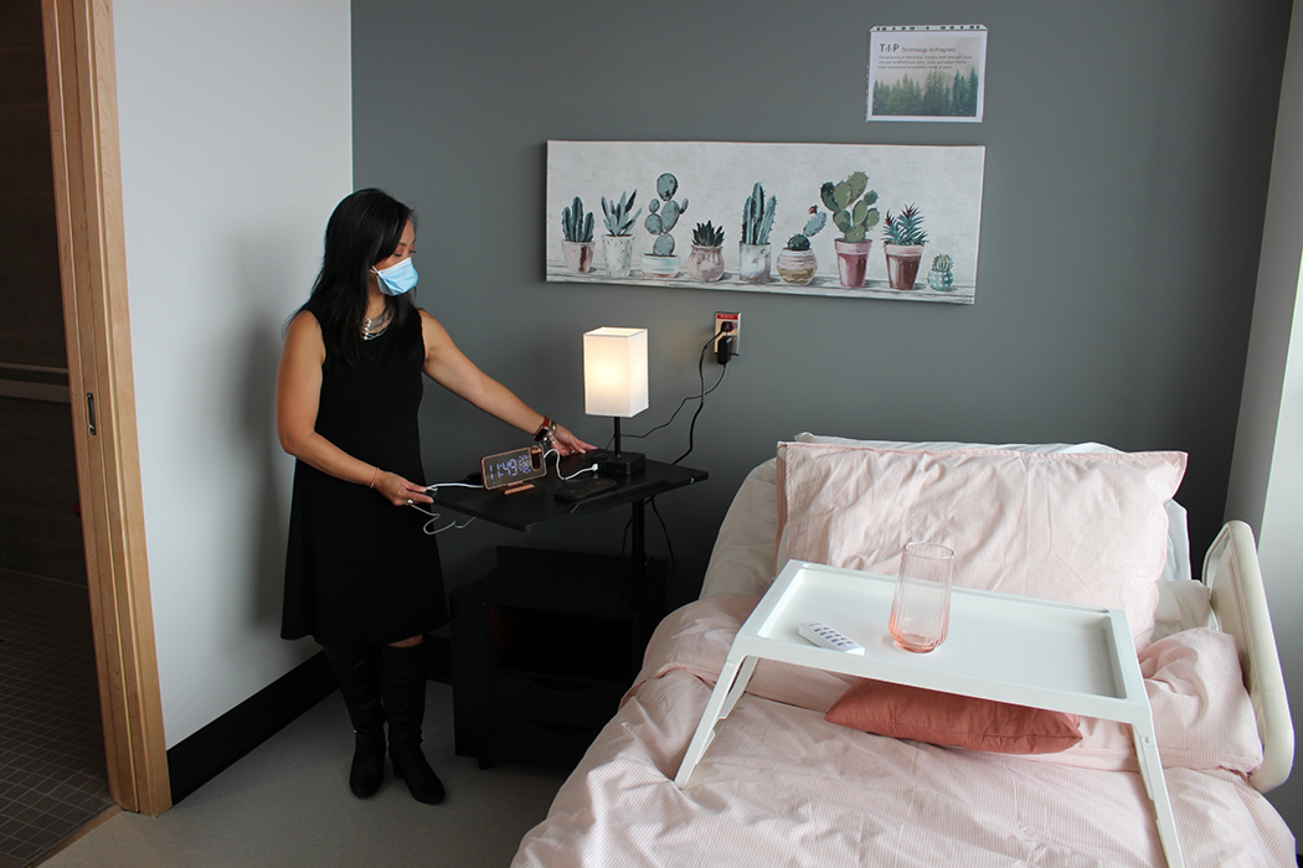 Maribel Abrenica moves the table, which a clock and lamp sit on.