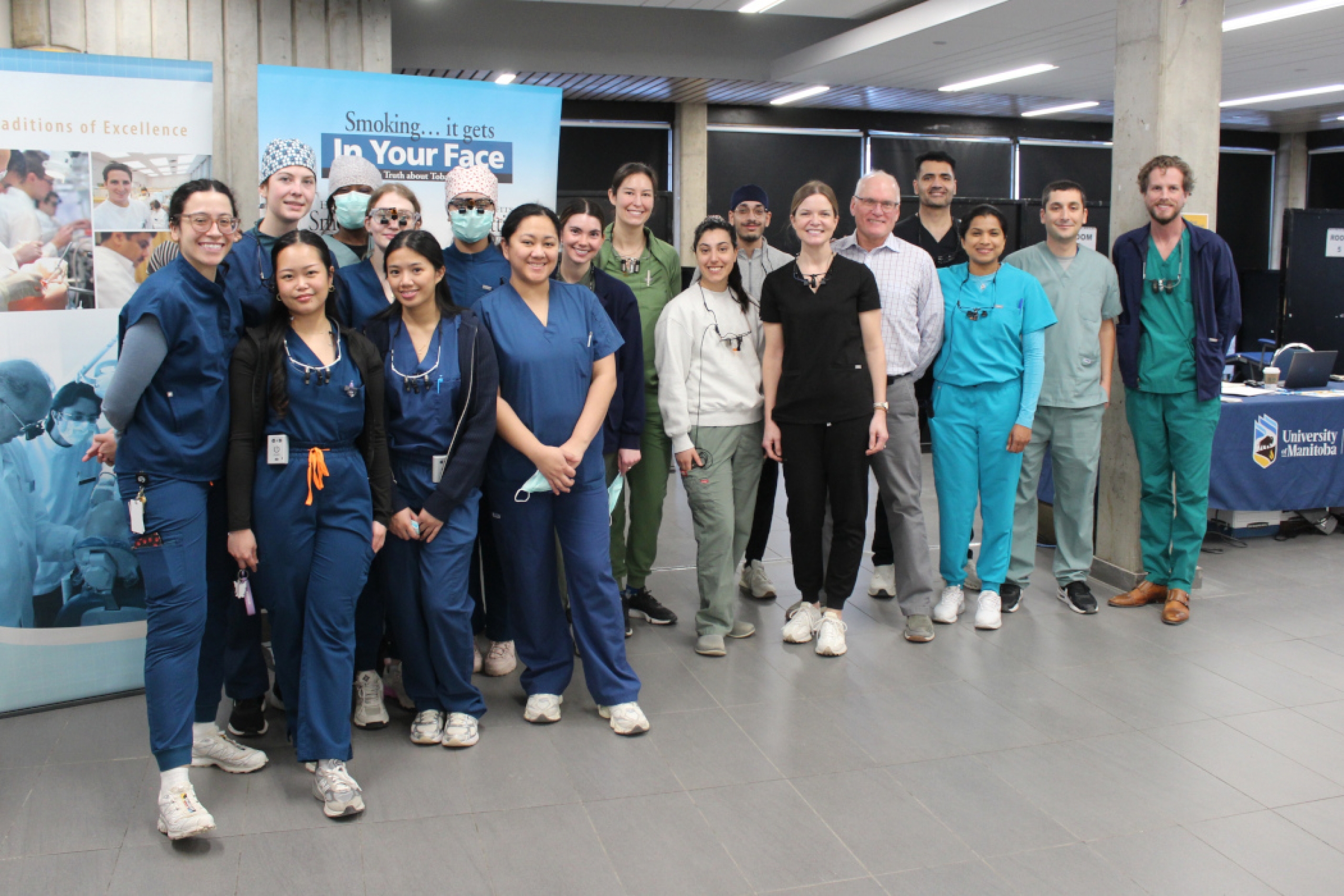 18 people pose for a photo in the makeshift clinic space.