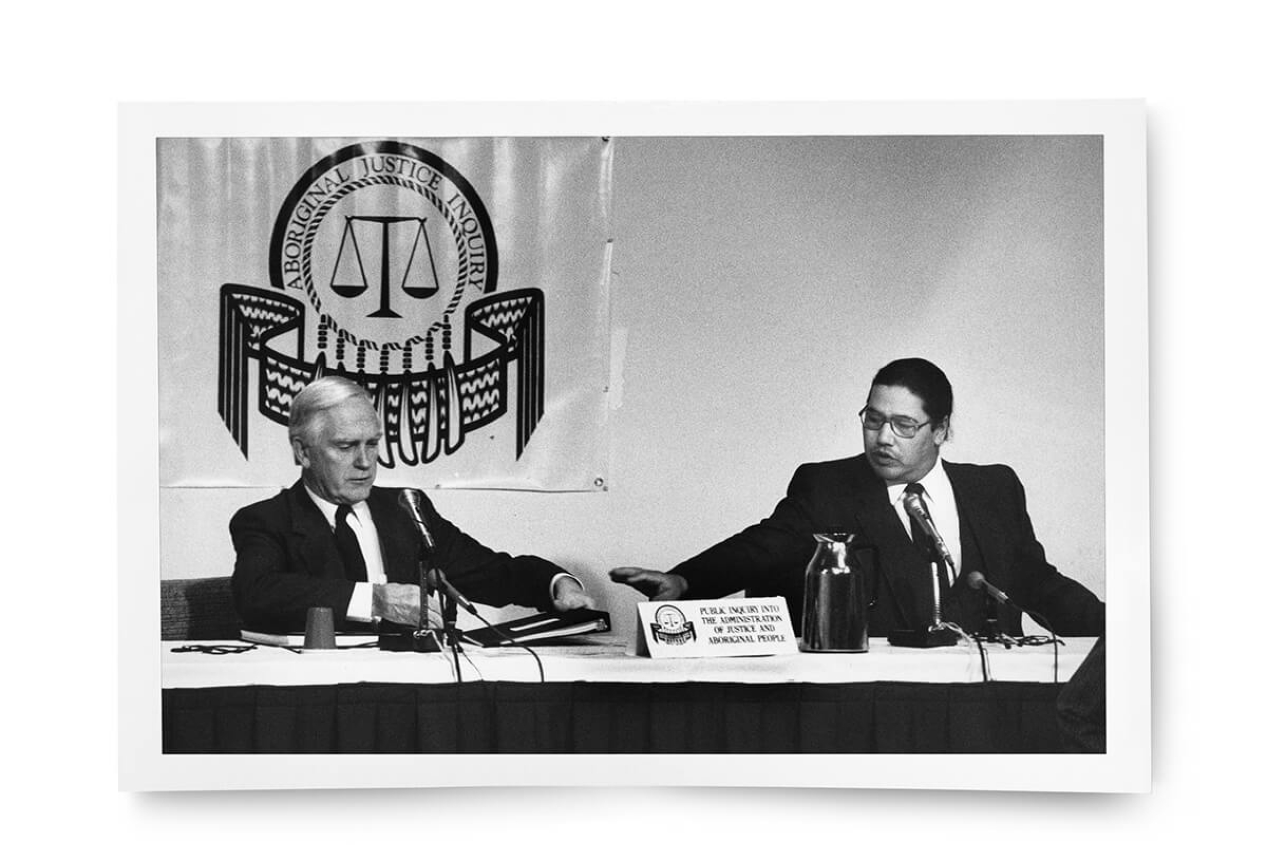 A black and white photo of Sinclair and another man at a table during his time working on the Aboriginal Justice Inquiry of Manitoba.