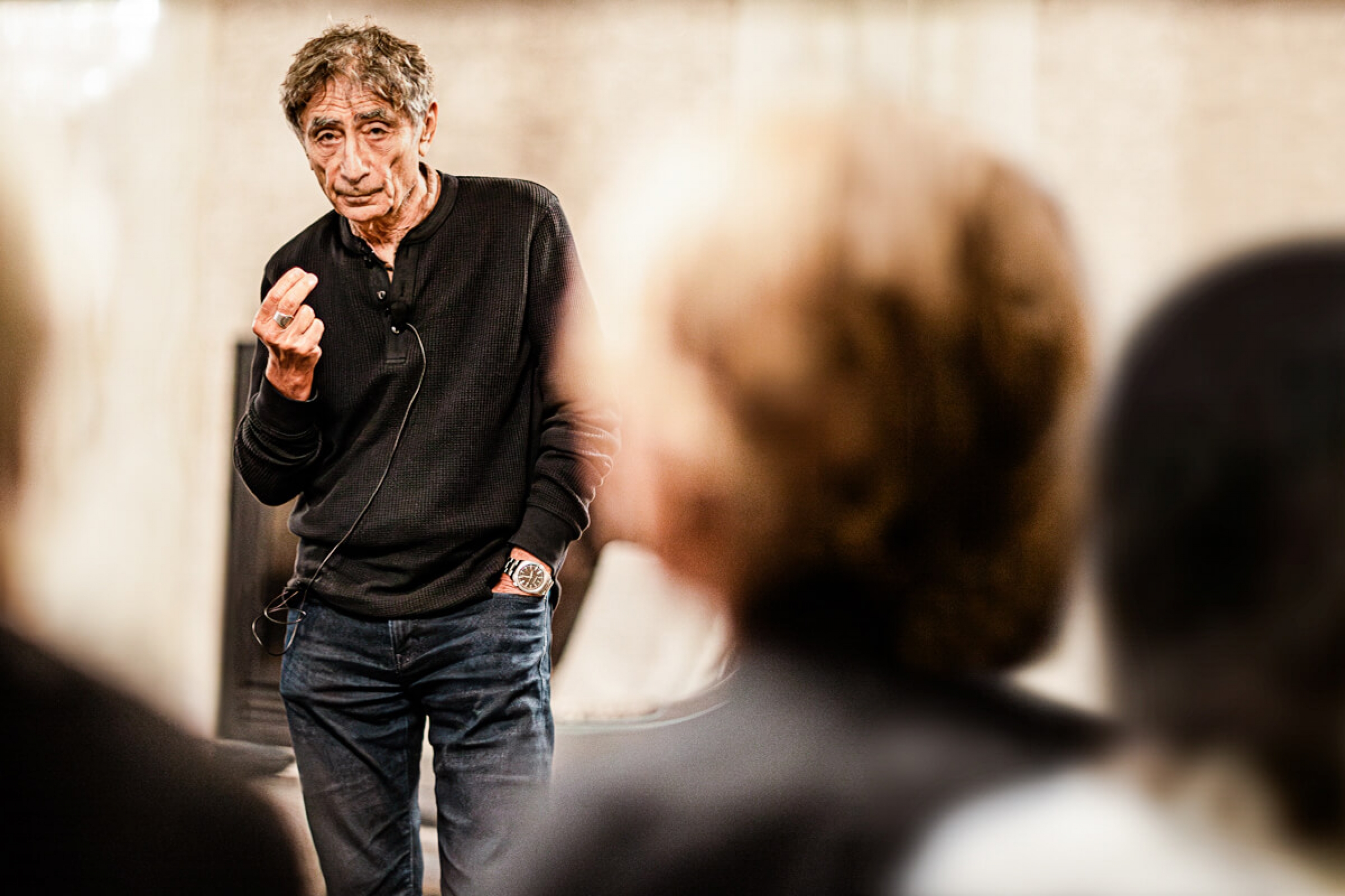 Gabor Mate speaks before a crowd.