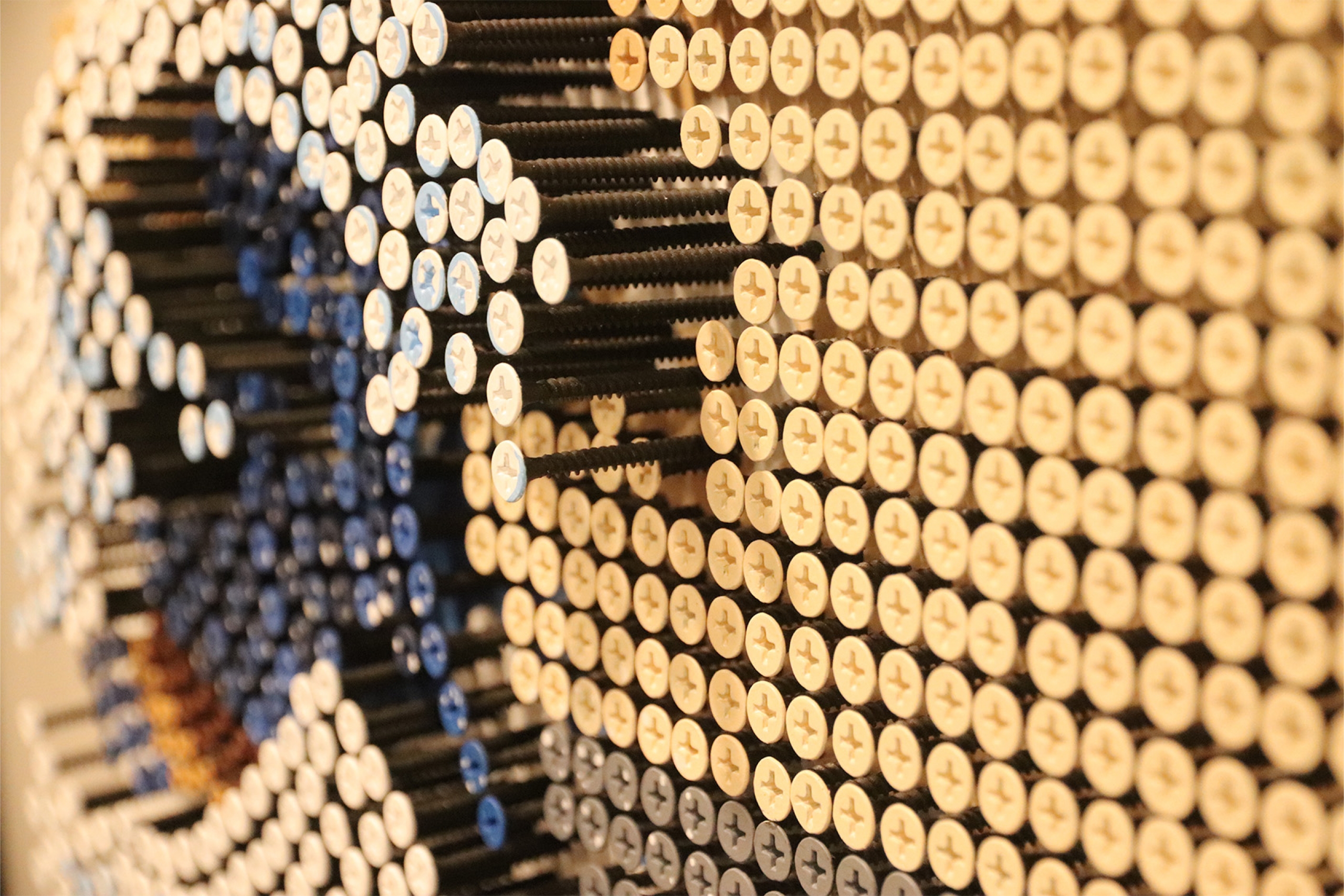 A upclose photo of a screw art piece showing the texture and depth of the screws.