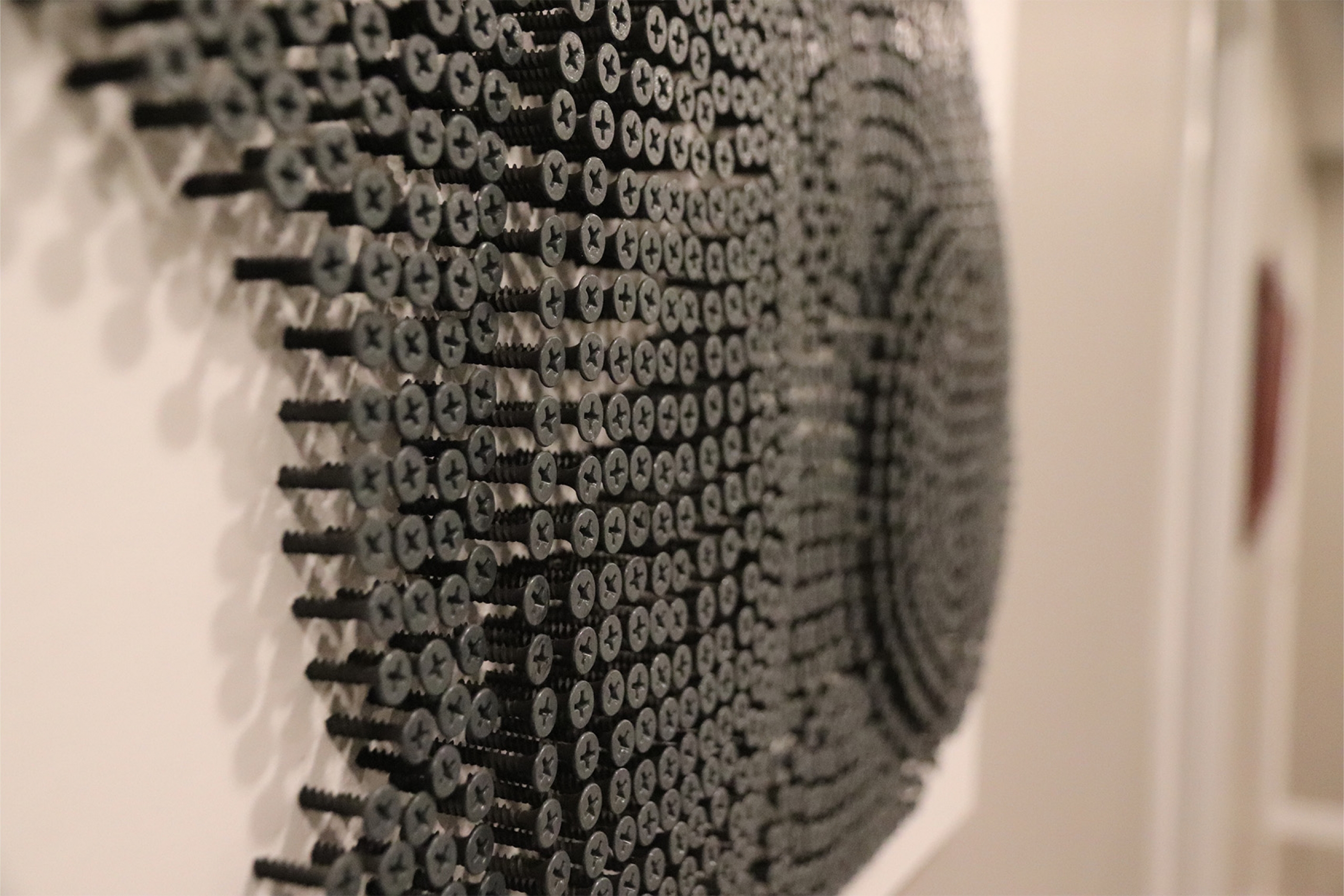 An up close perspective of a one colour screw art piece.