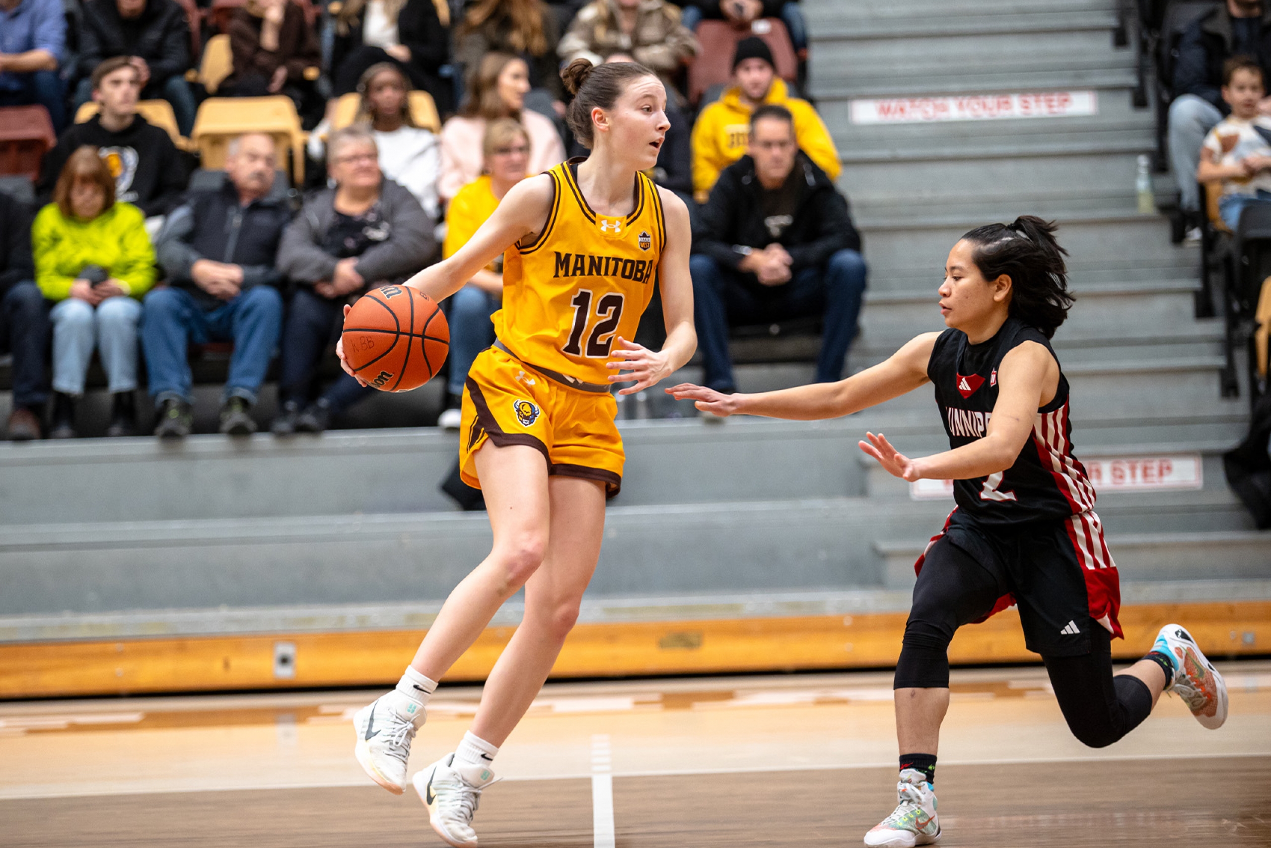A women's basketball player avoids the opposing team.