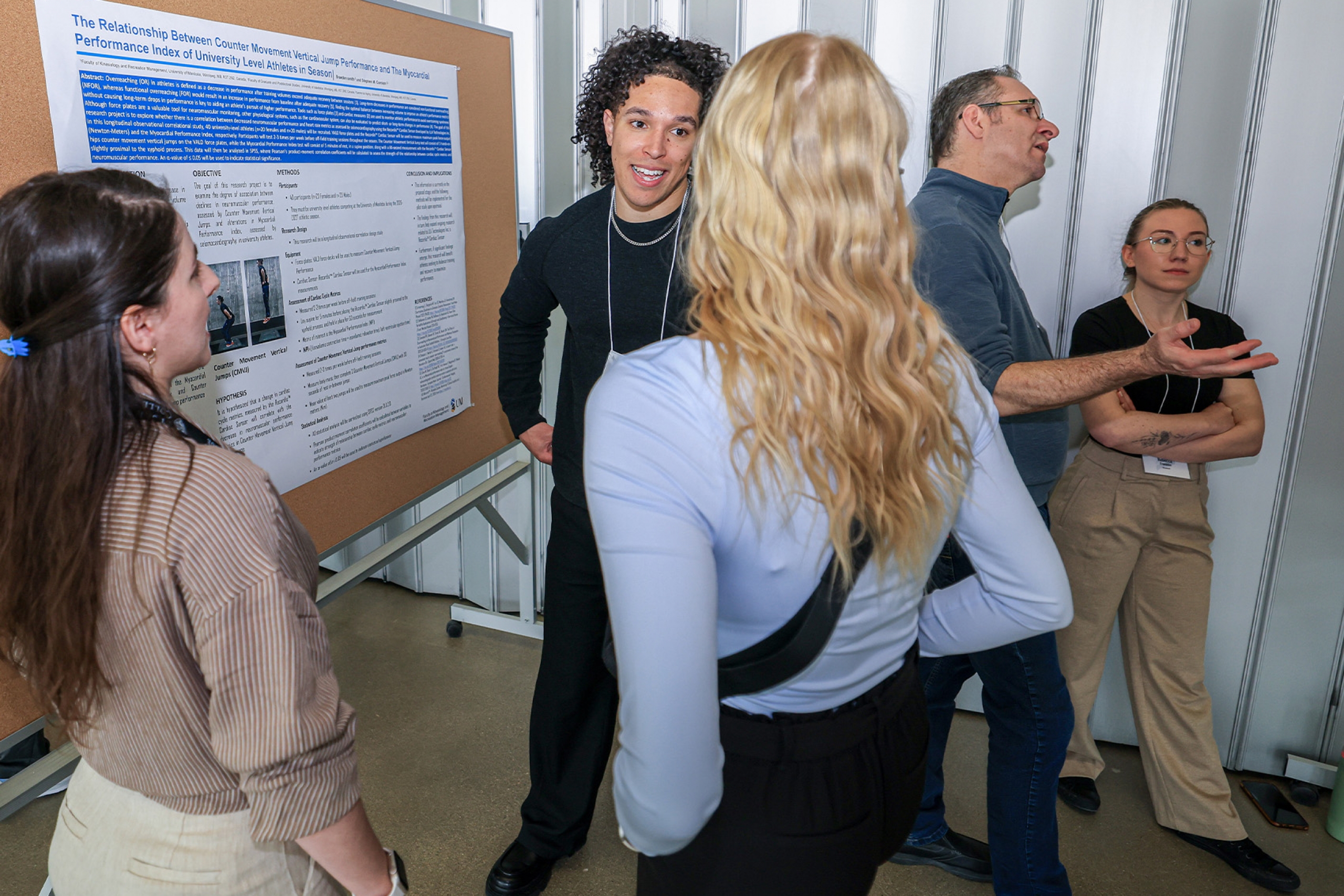 A student explains his research to participants at Research Day.