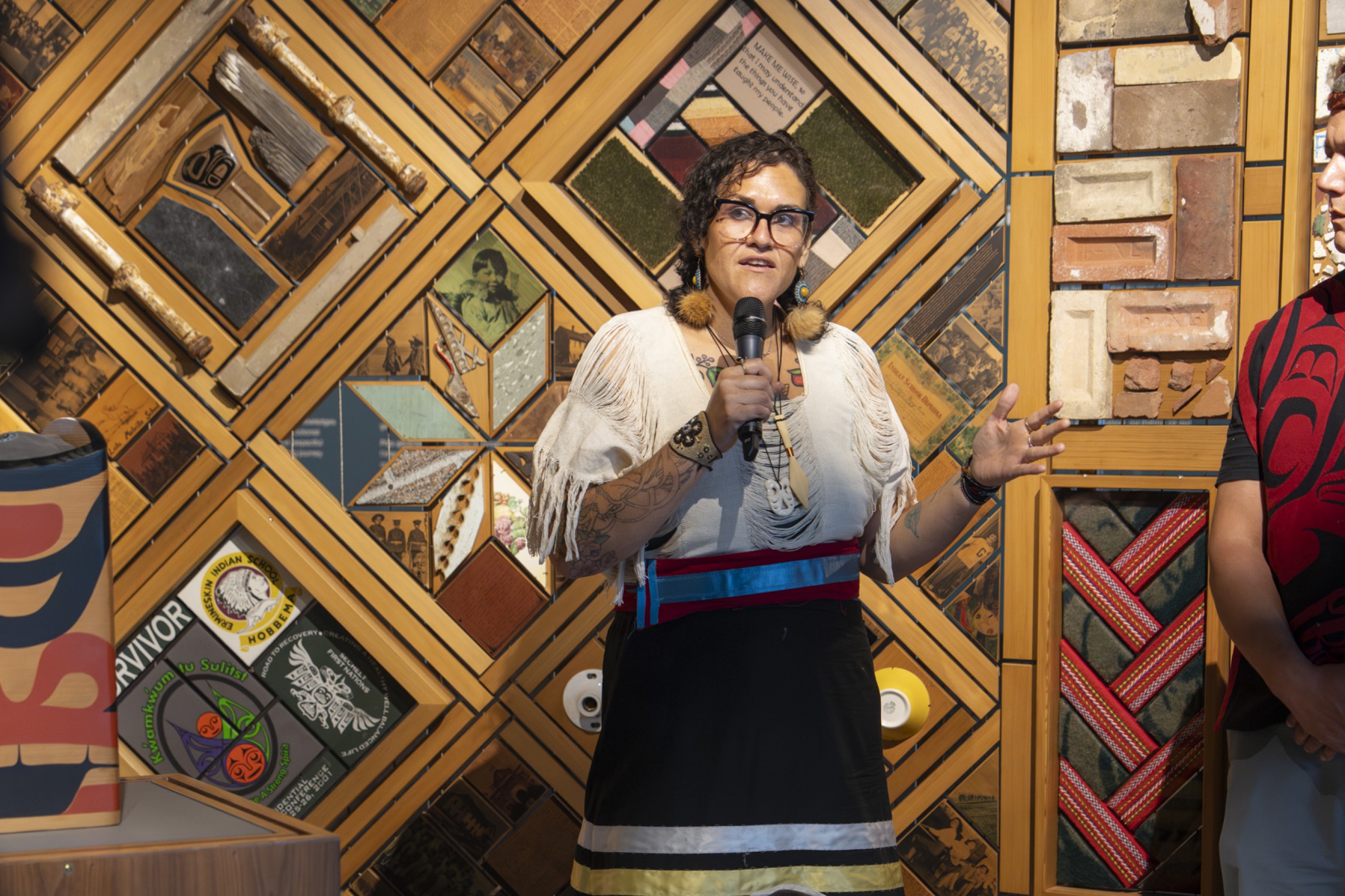 Aimee in a ribbon skirt presents at an event.