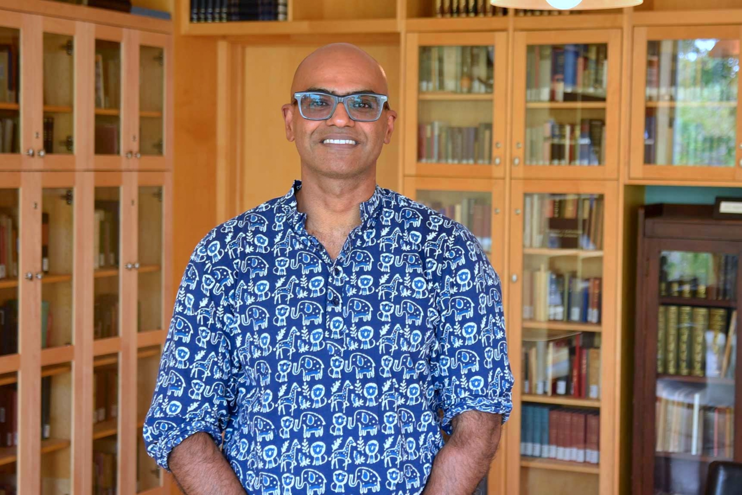 Abishek Iyer wearing a patterned button down shirt smiling at the camera.