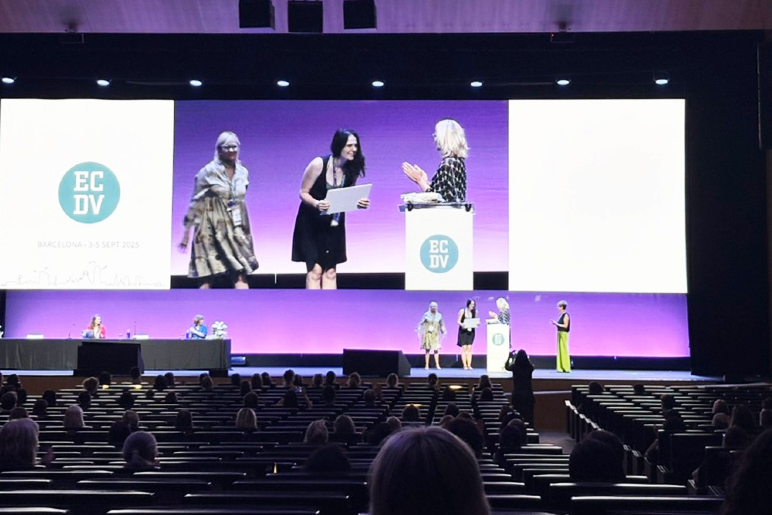 AmyAnne on stage at the European Conference on Domestic Violence in Barcelona receiving award.