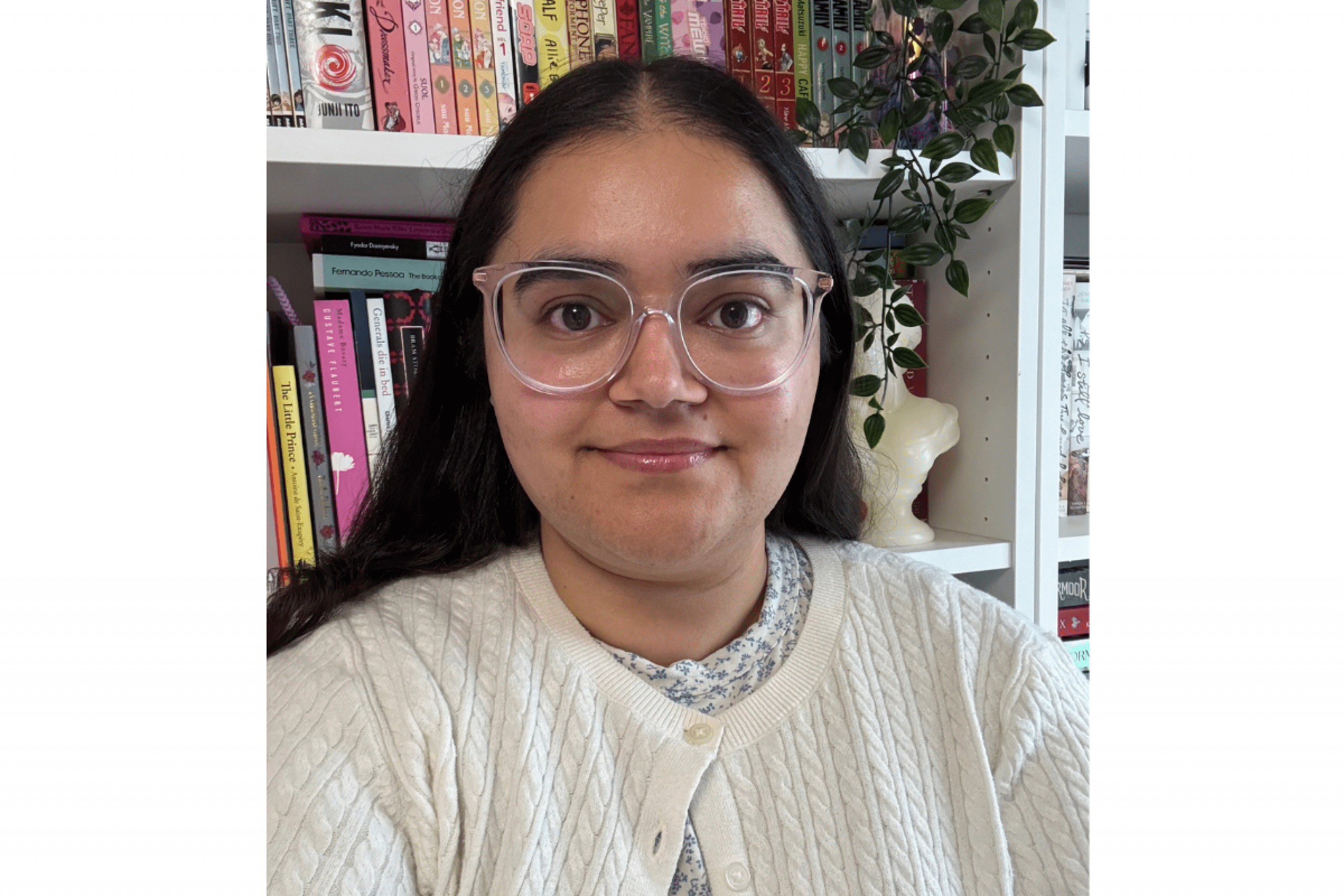 female student wearing glasses in front of bookshelf