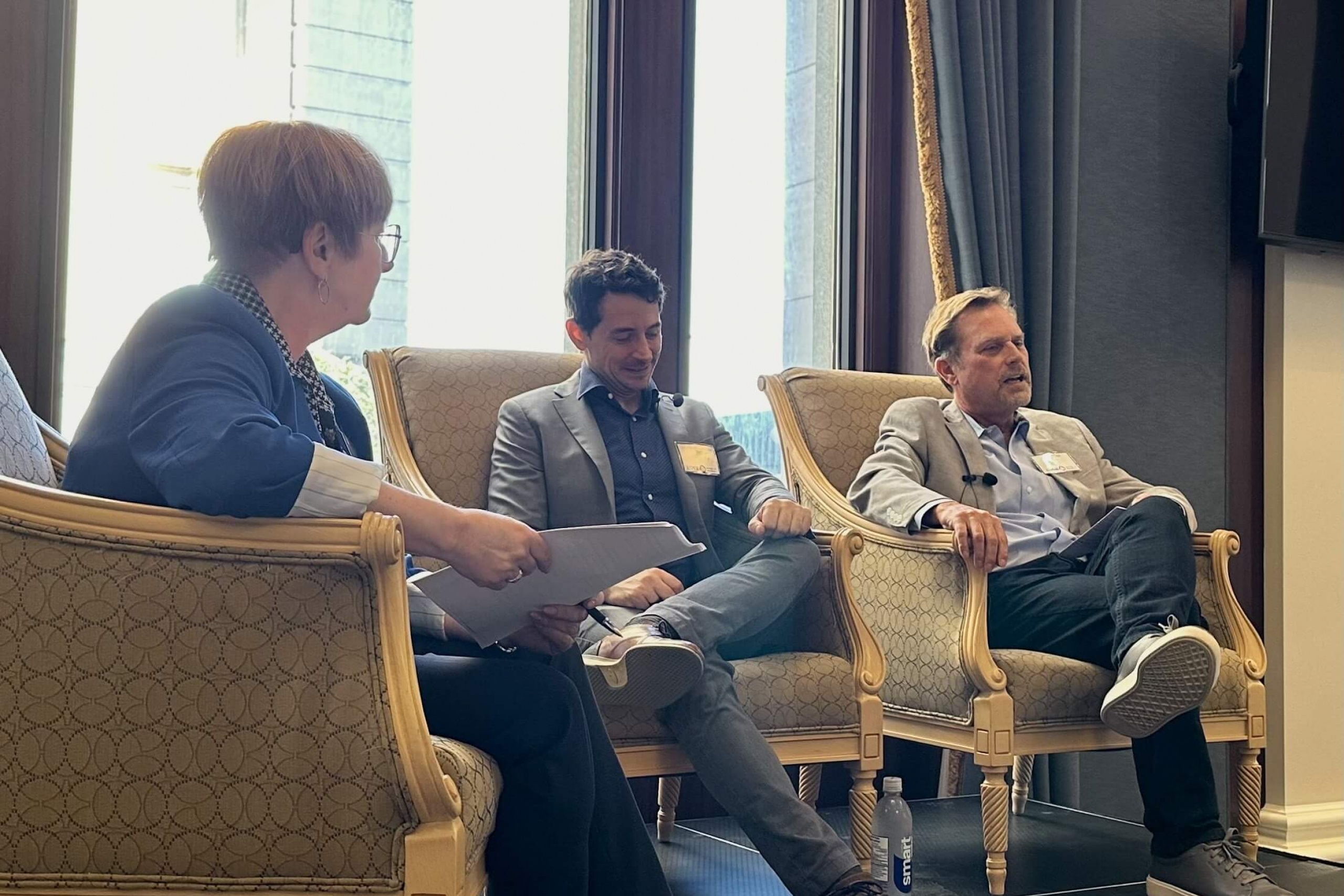 Three speakers sit in armchairs at the Asper After Five event.
