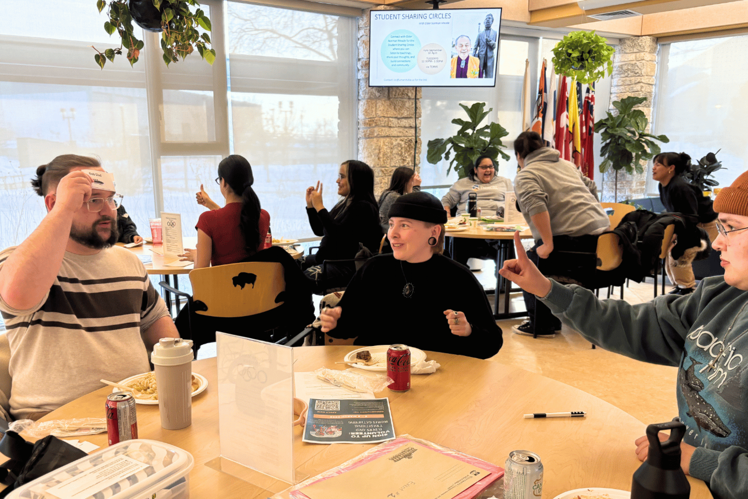 Students gather around tables during a Blankstein Momentum Program sharing circle, talking, eating and participating in a group activity.