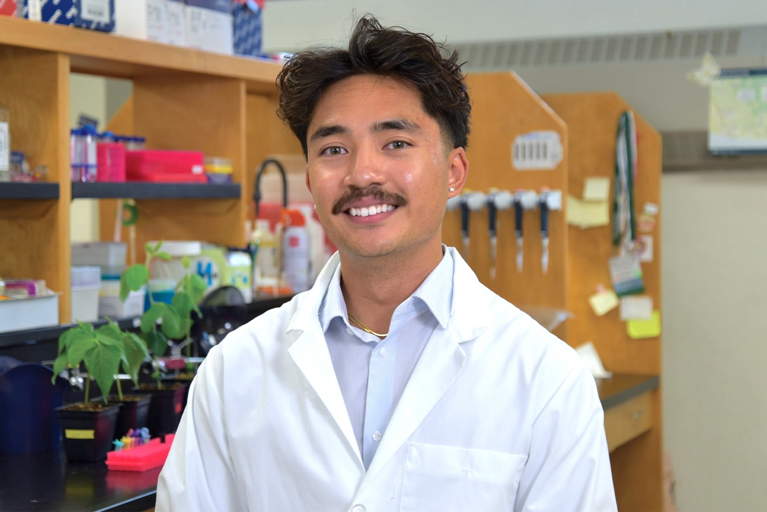 Brigo wearing a lab coat smiling at the camera.