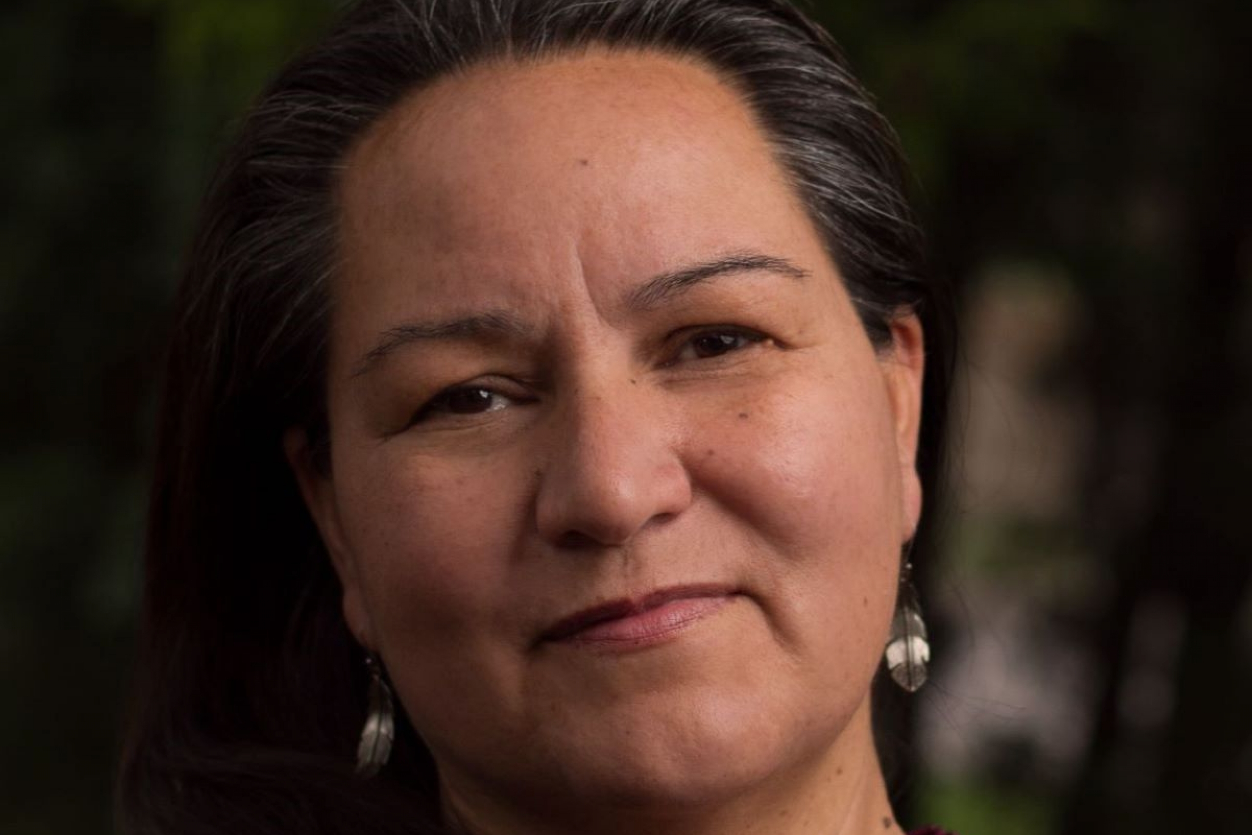 A headshot image of Christine Cyr, looking at the camera and wearing a purple shirt.