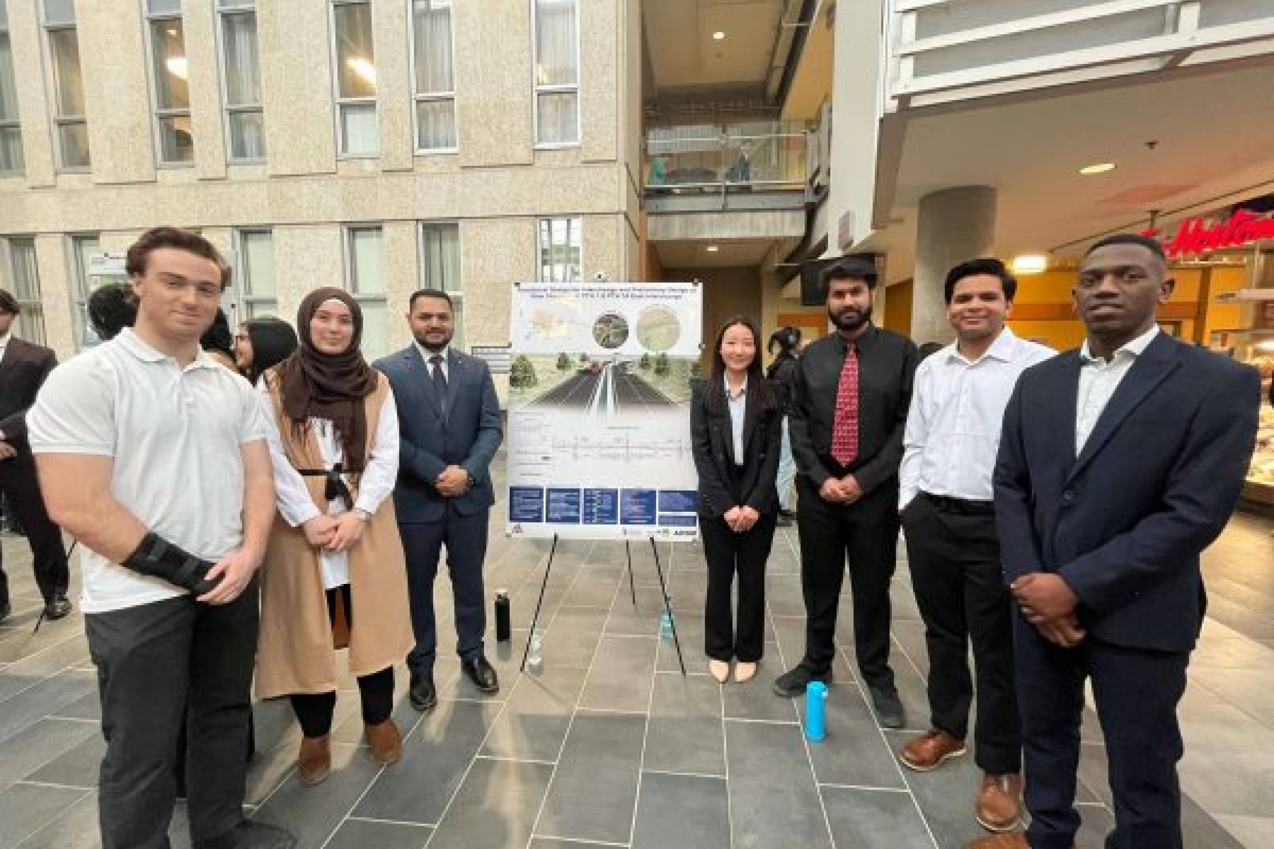 students posing in front of poster display