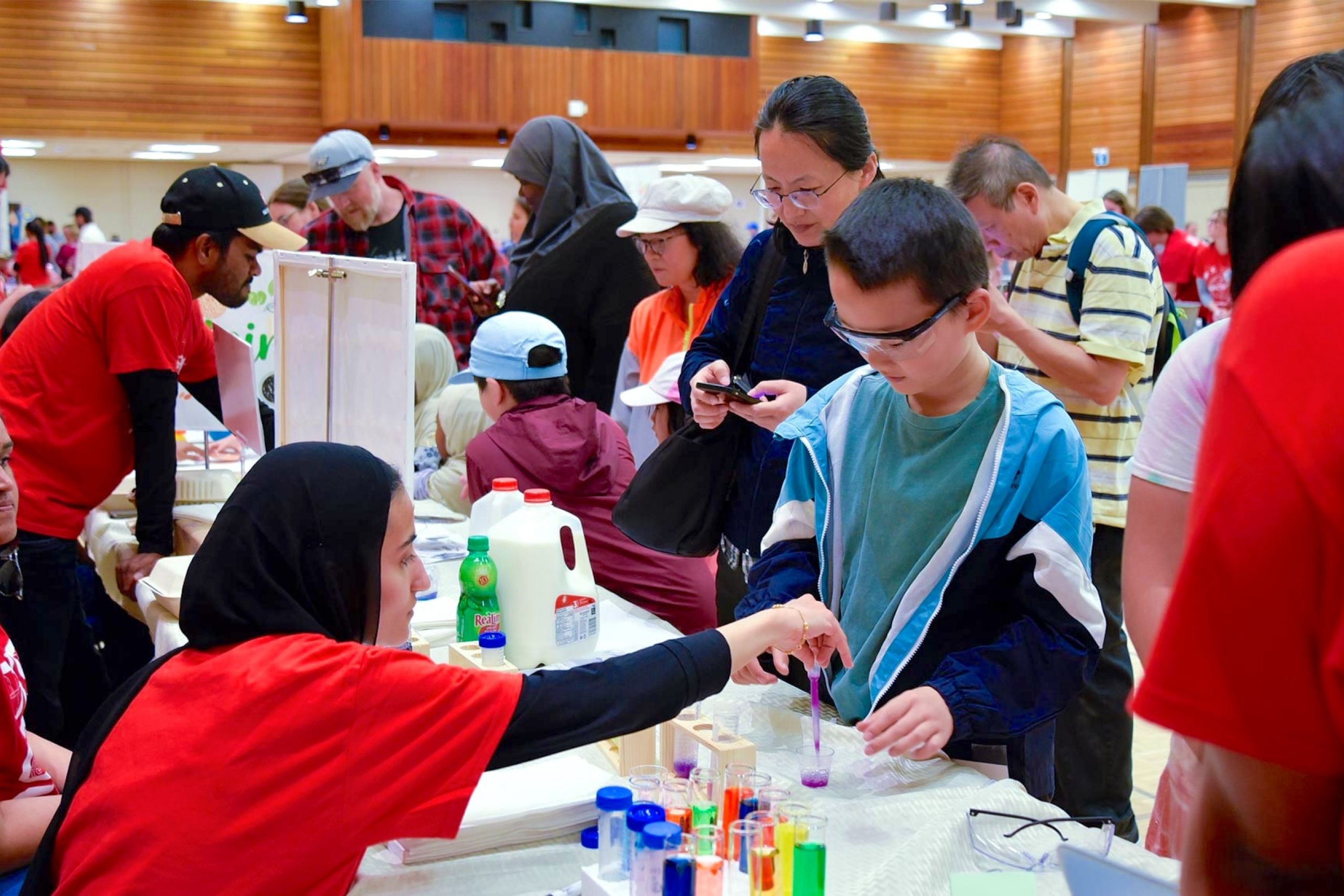 A curious kid checking out some colorful liquids.
