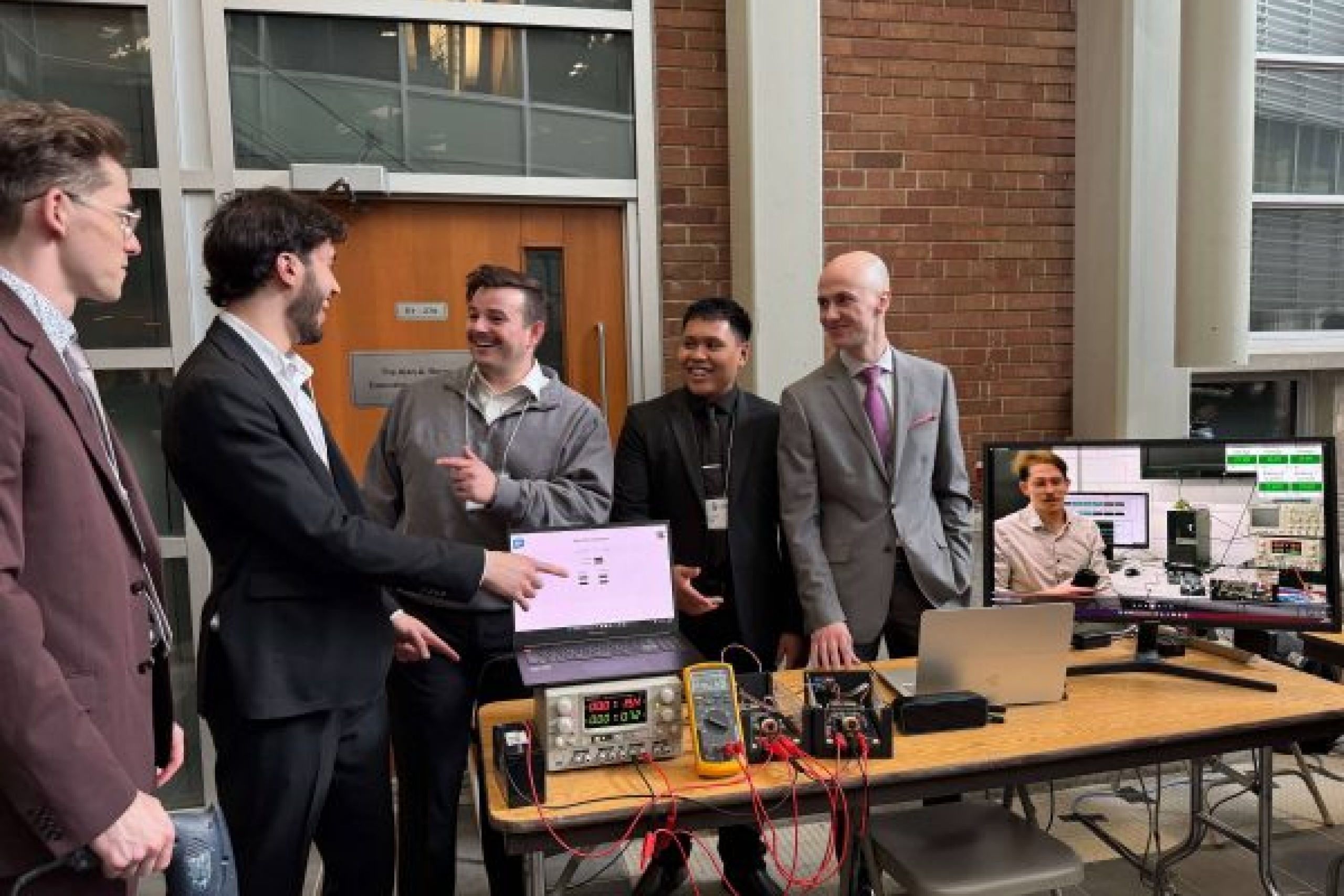 Students showcasing prototype at table