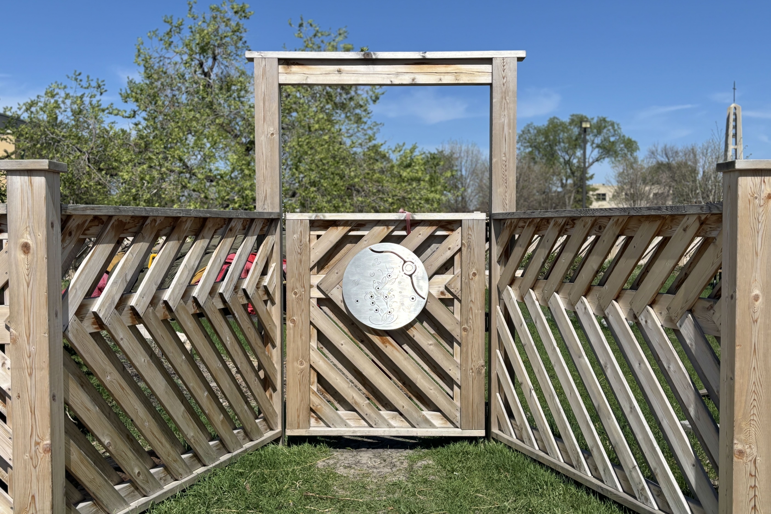 wooden gate with round, silver medallion