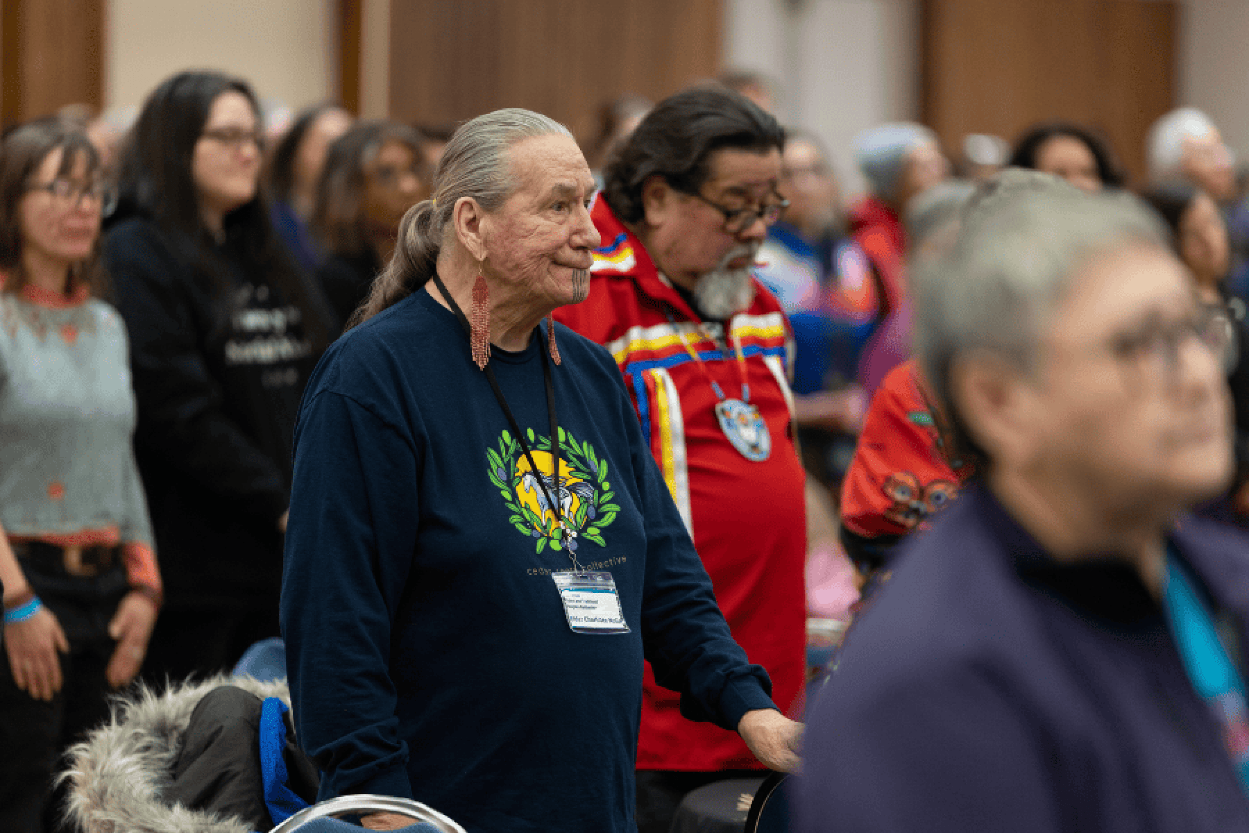 Attendees stand and participate during a session.