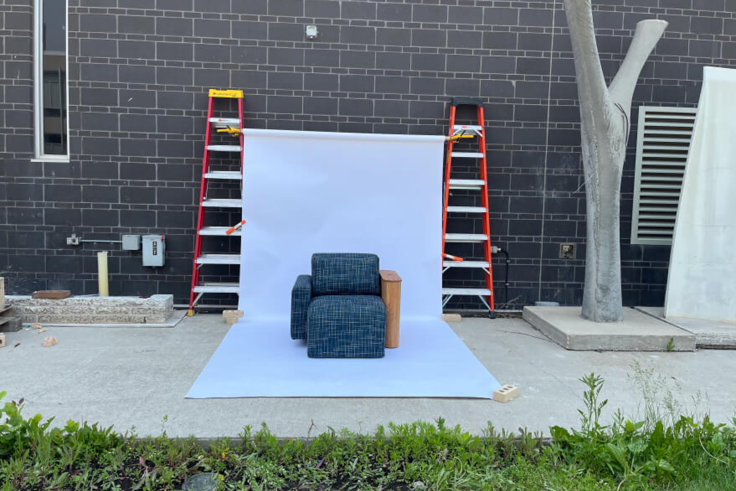 A completed, upholstered chair displayed in front of a white backdrop for a showcasing photo.