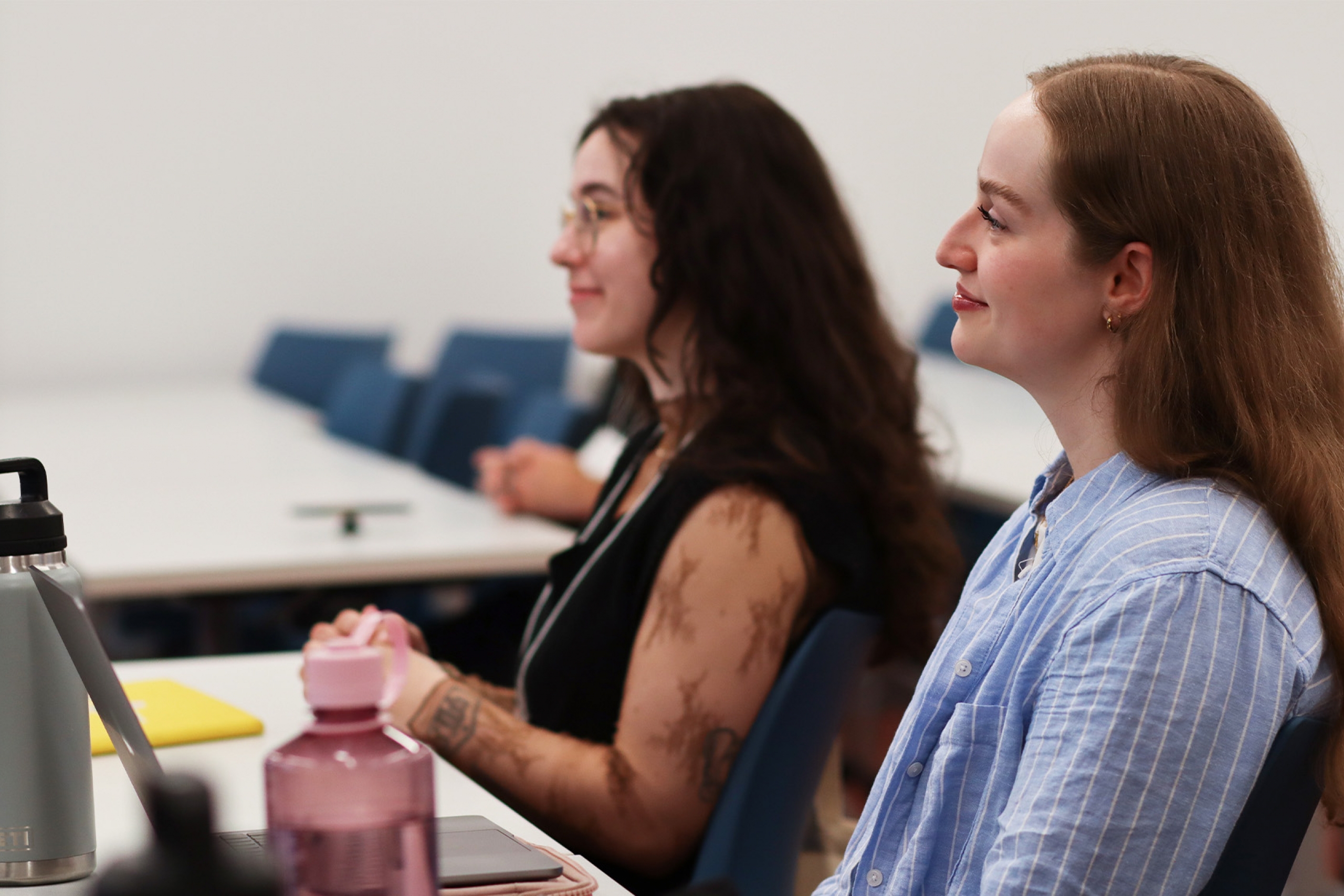 Two graduate students smiling during a presentation