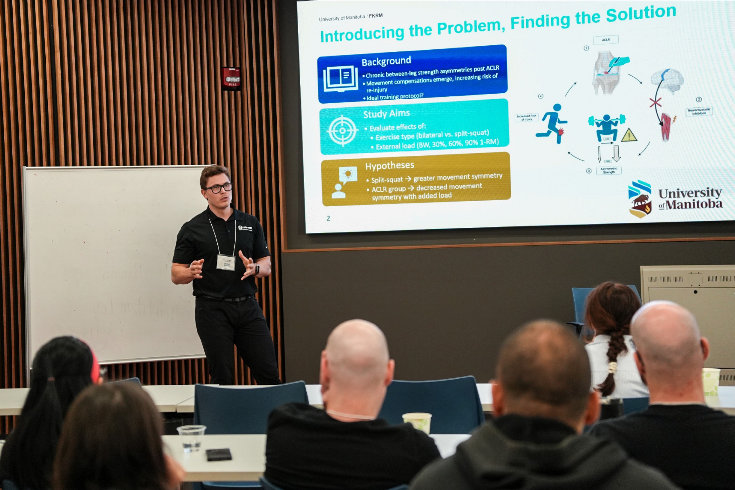 A graduate student standing during an oral presentation