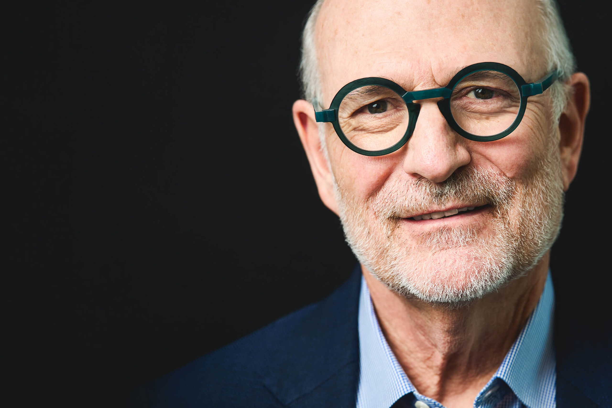 Harvey Chovinov, on a black background, looking at the camera
