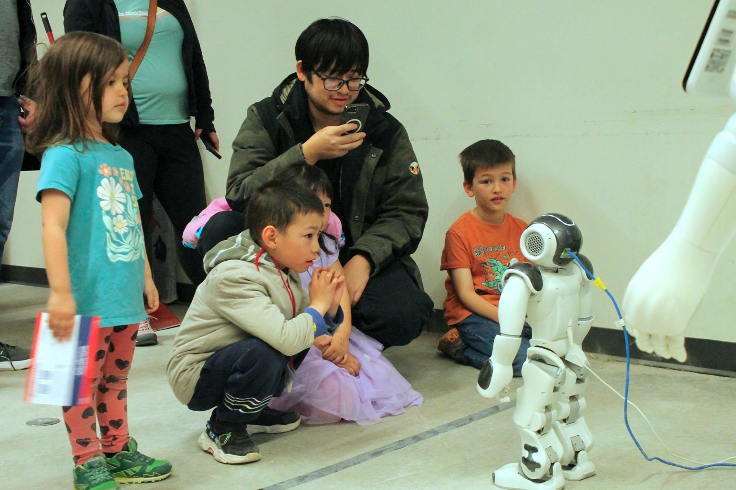 Kids interacting with the small robot at the HCI Lab booth.