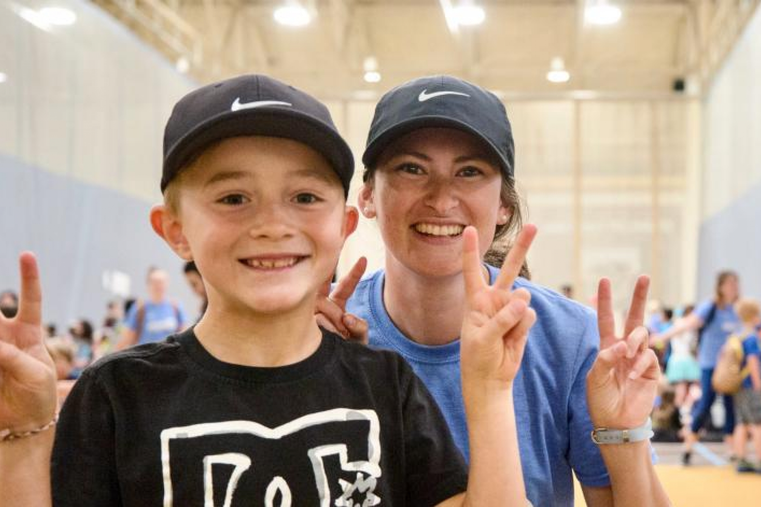 A child and camp leader holding up peace signs