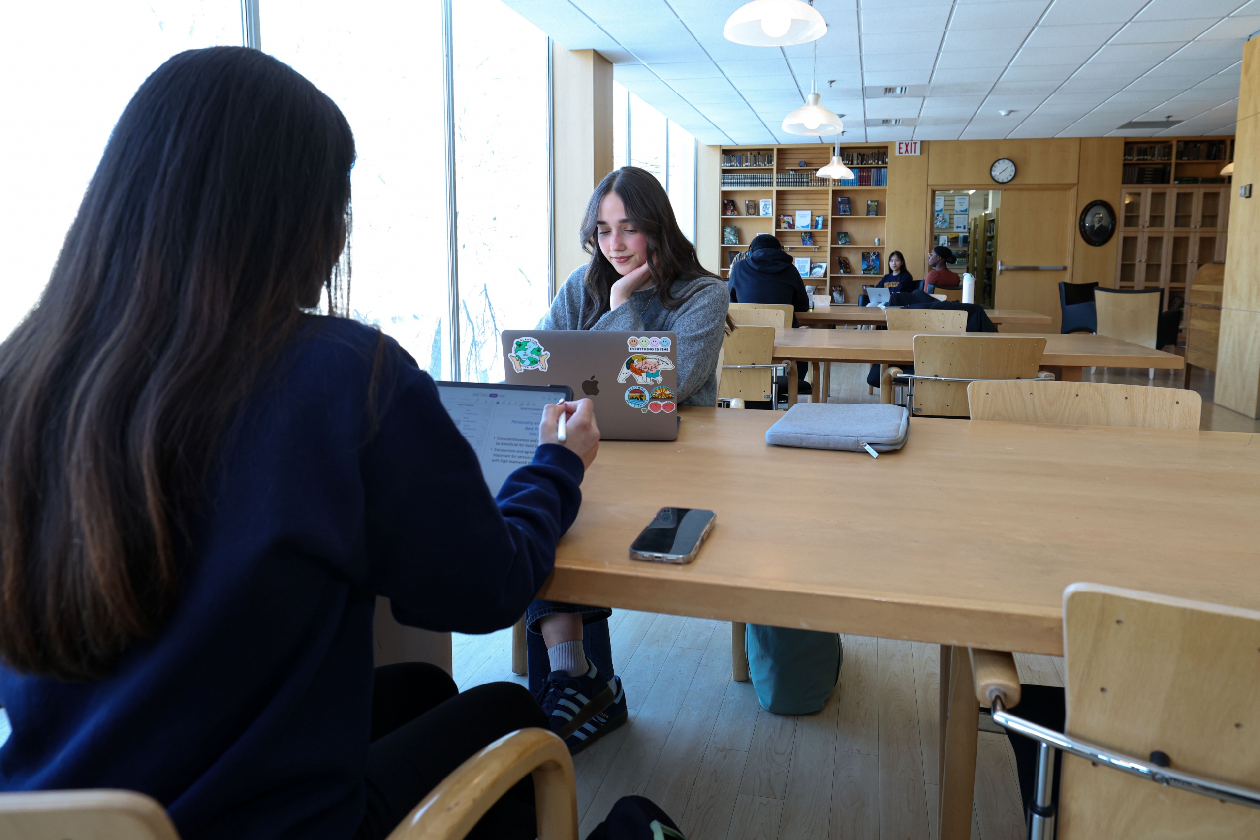 Students studying in a brightly lit, modern study space