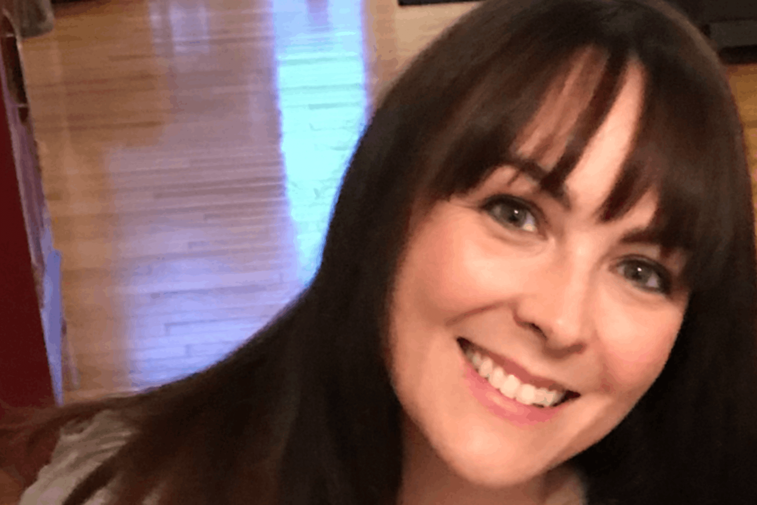 woman with black hair smiling to the camera.