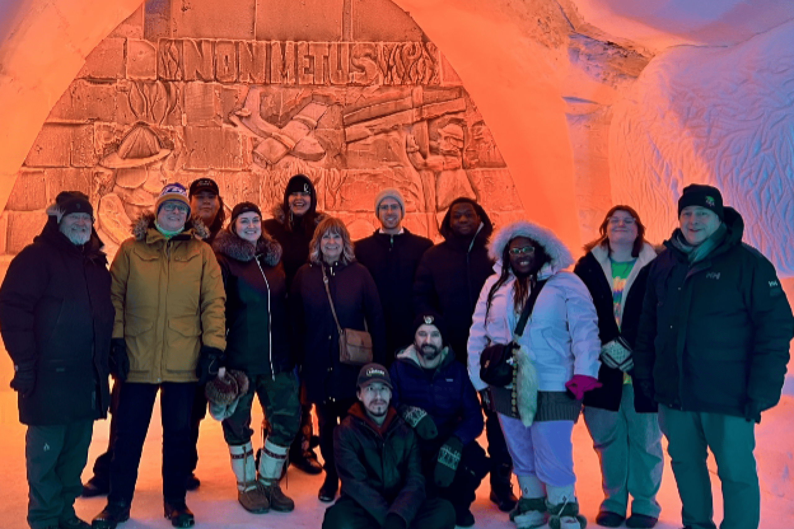 A group of people in parkas stand inside Flin Flon's famous snow lodge