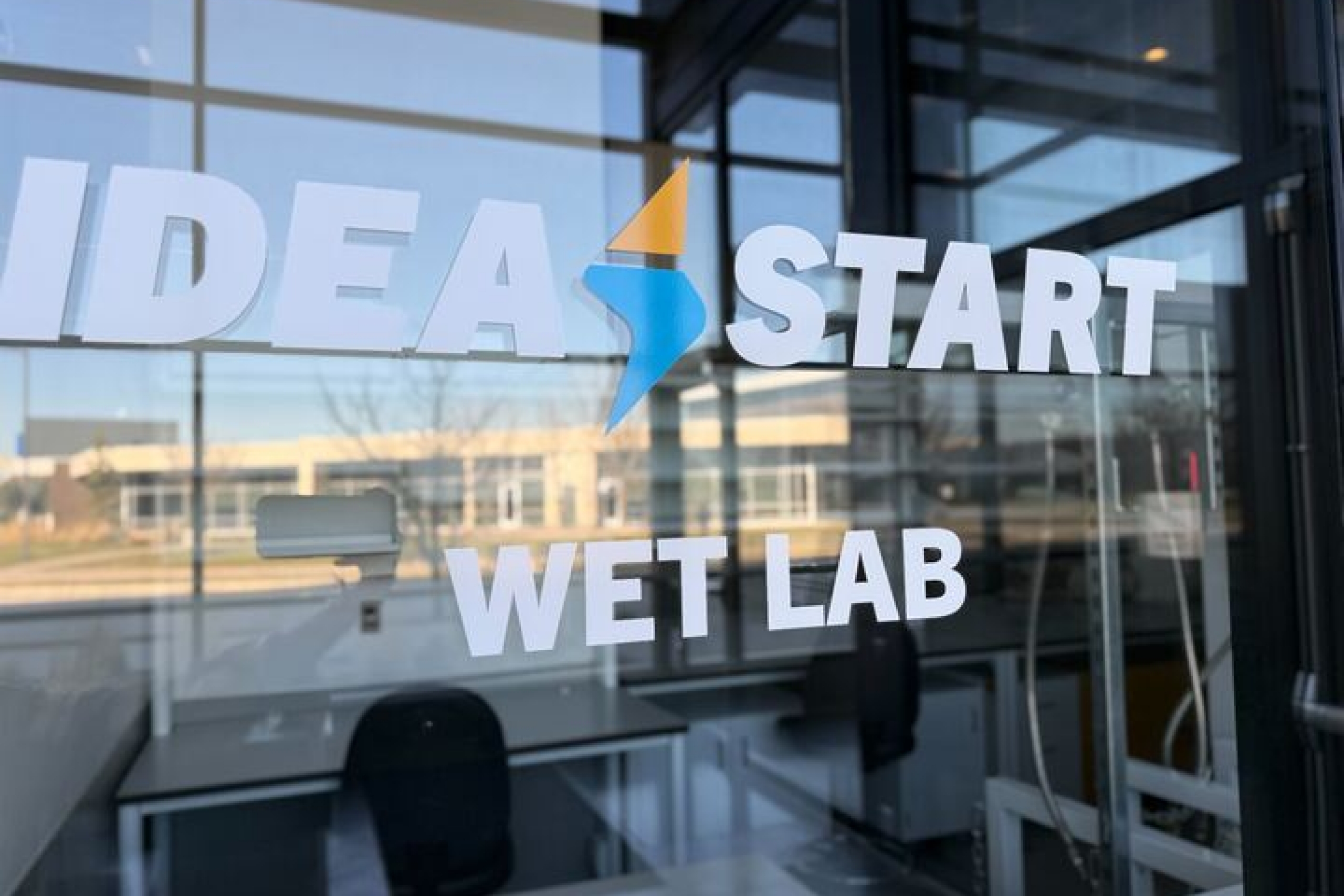 Glass entrance to the IDEA START wet lab, with the IDEA START logo and “WET LAB” displayed on the door.