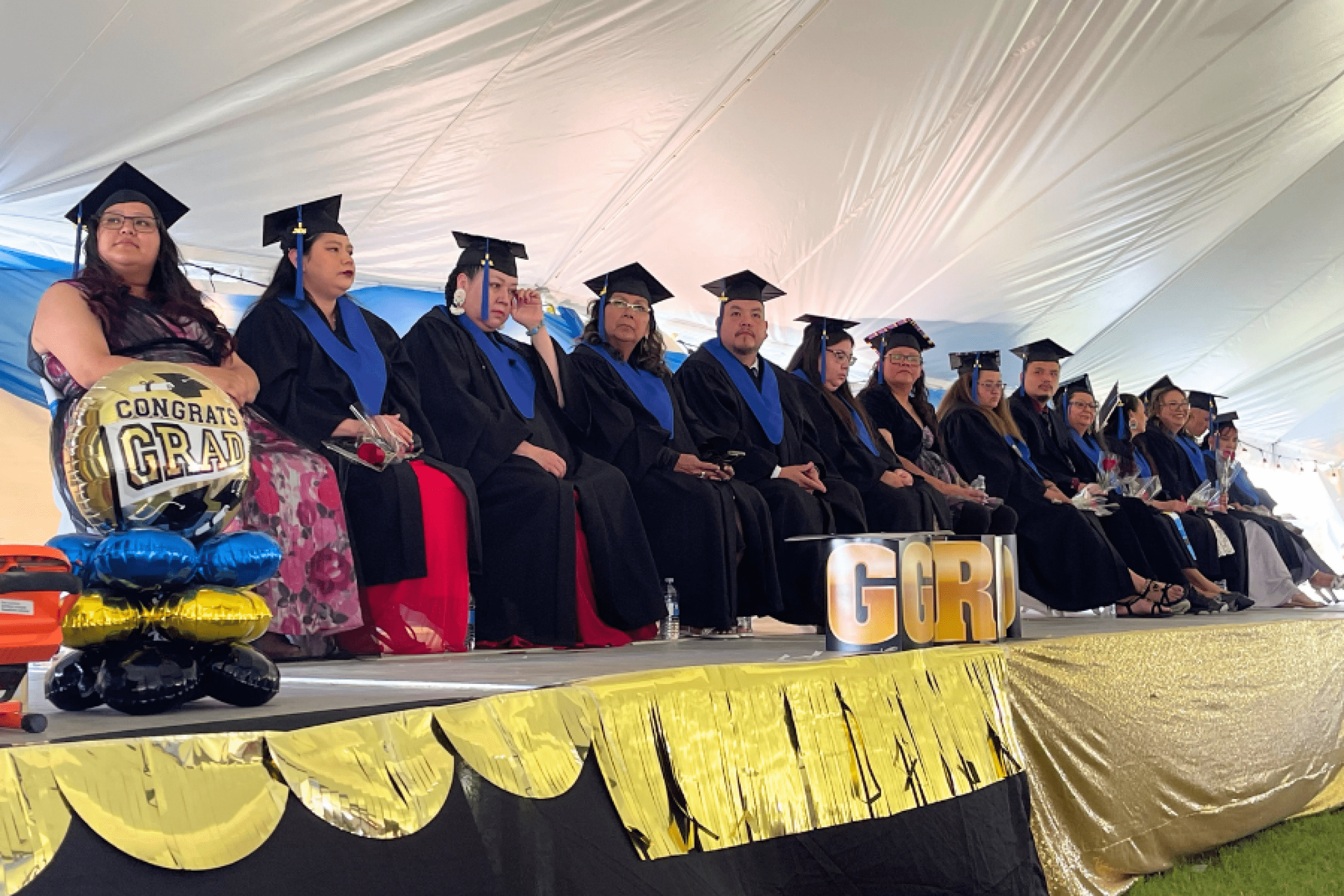 Graduates seated on stage during the ceremony.